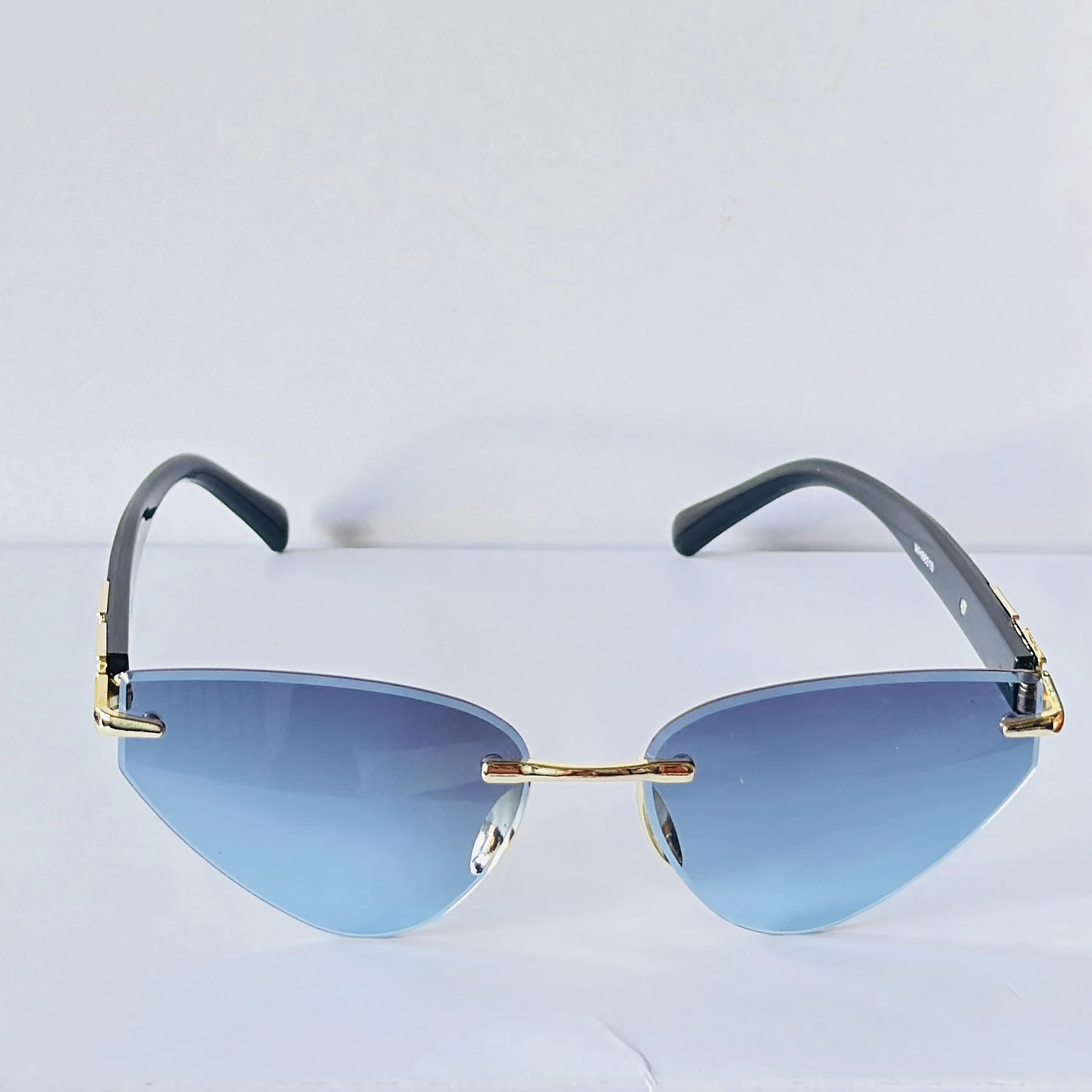 Rimless cat-eye sunglasses feature golden metal frame