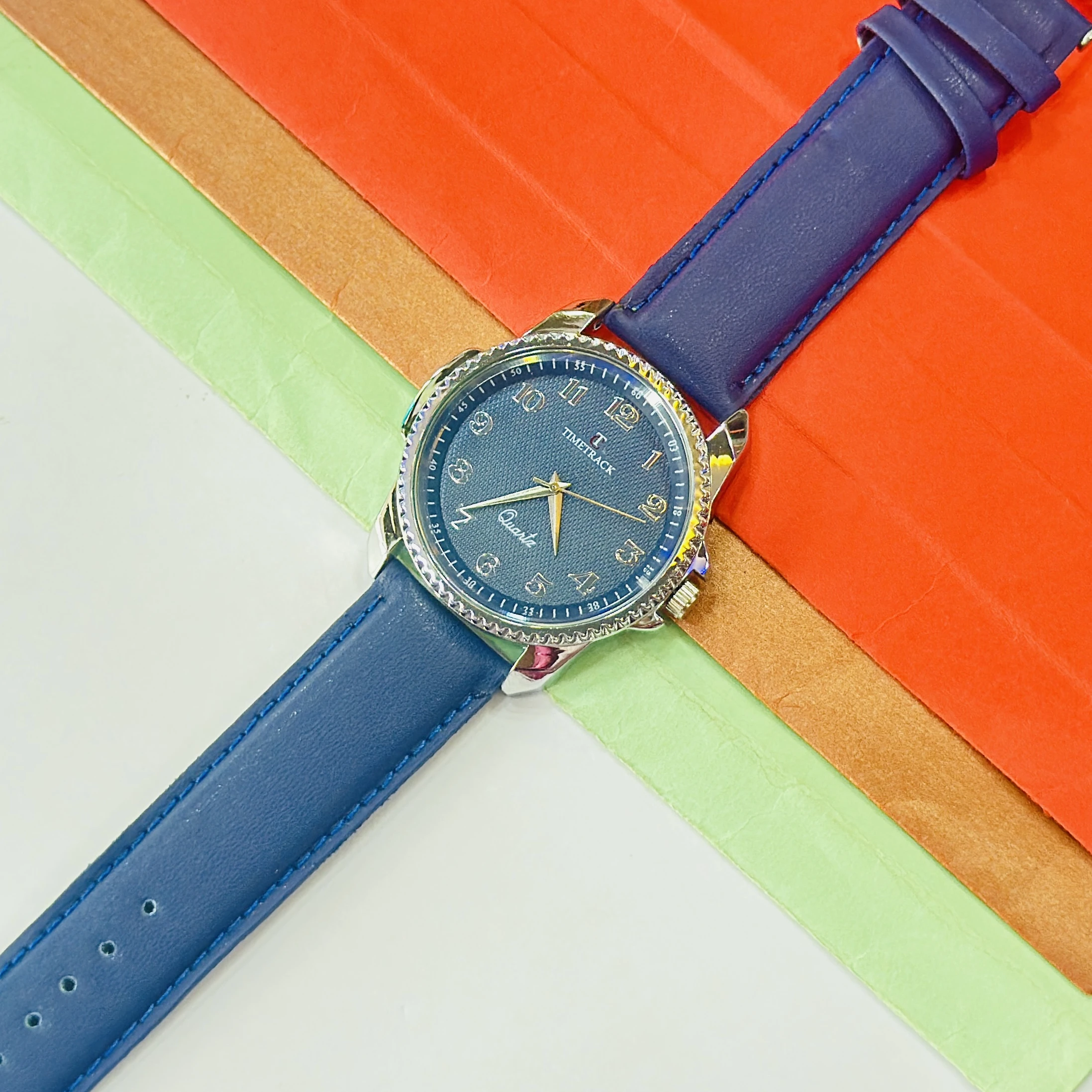 quartz analog watch features a blue dial and a matching navy blue leather strap