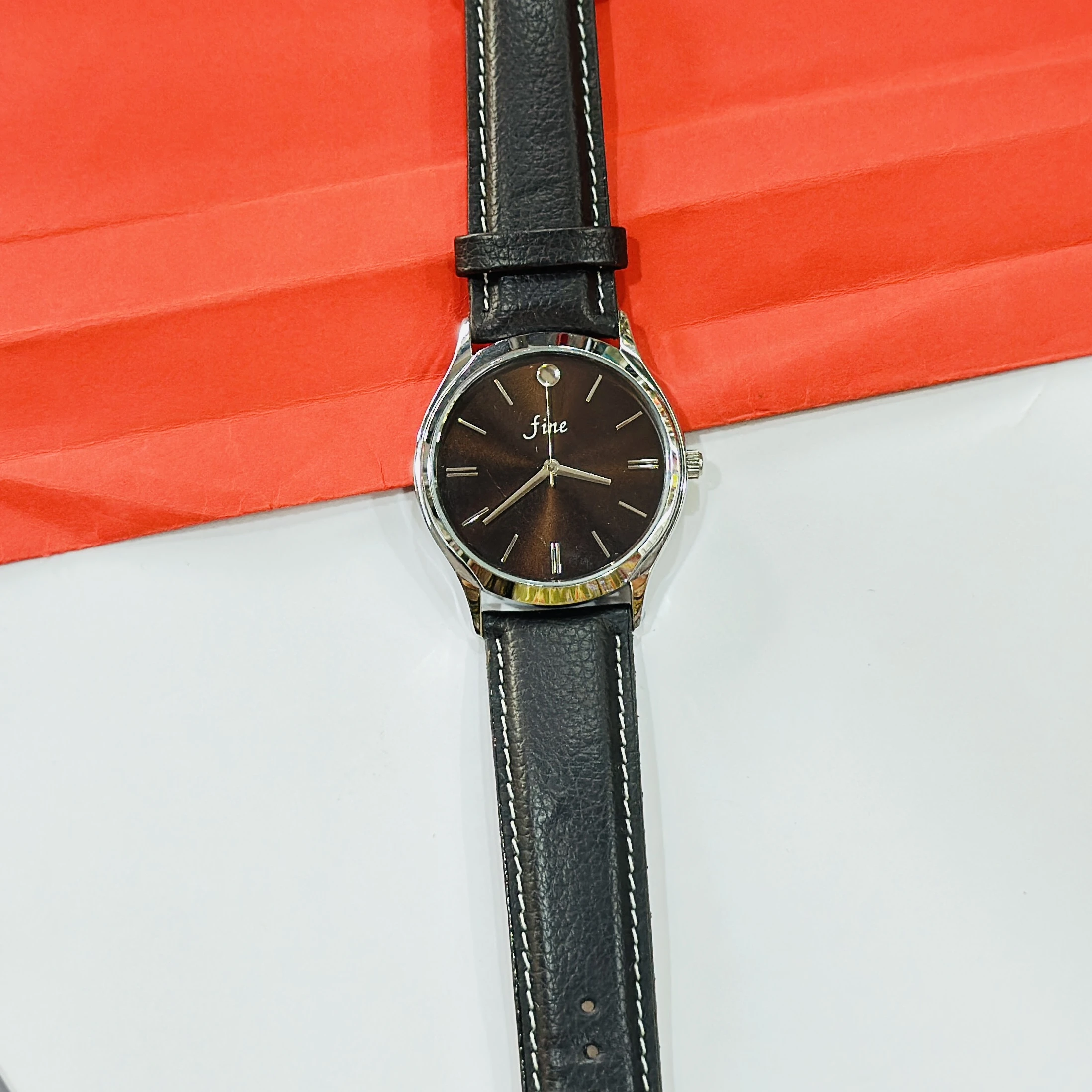wristwatch featuring a black textured leather strap