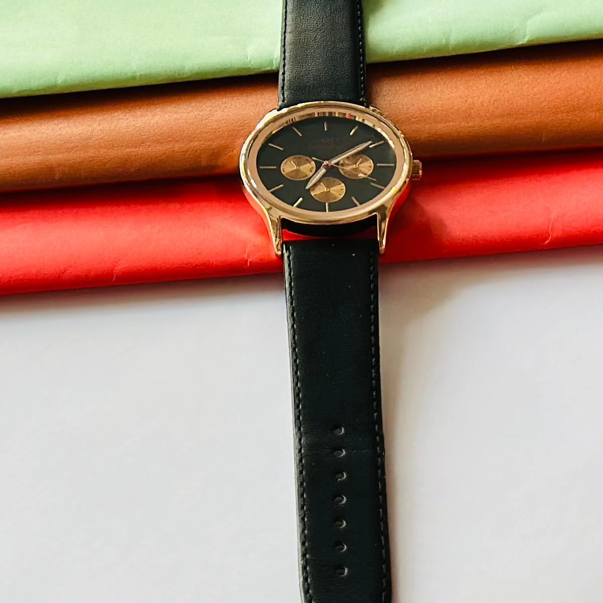 Round analog watch with a black leather strap