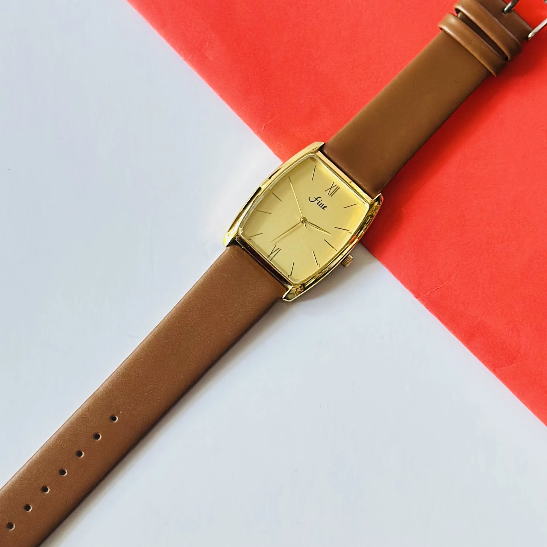 Gold toned GEDI women's quartz watch with a brown leather strap.