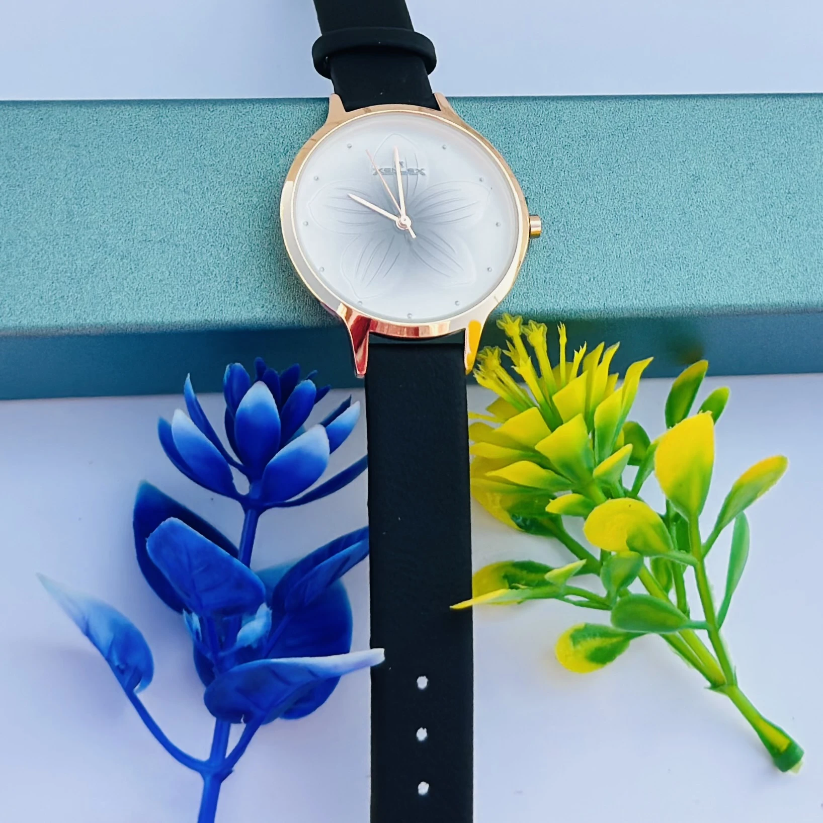 Analog with Pink Dial watch for women with a black plastic strap.