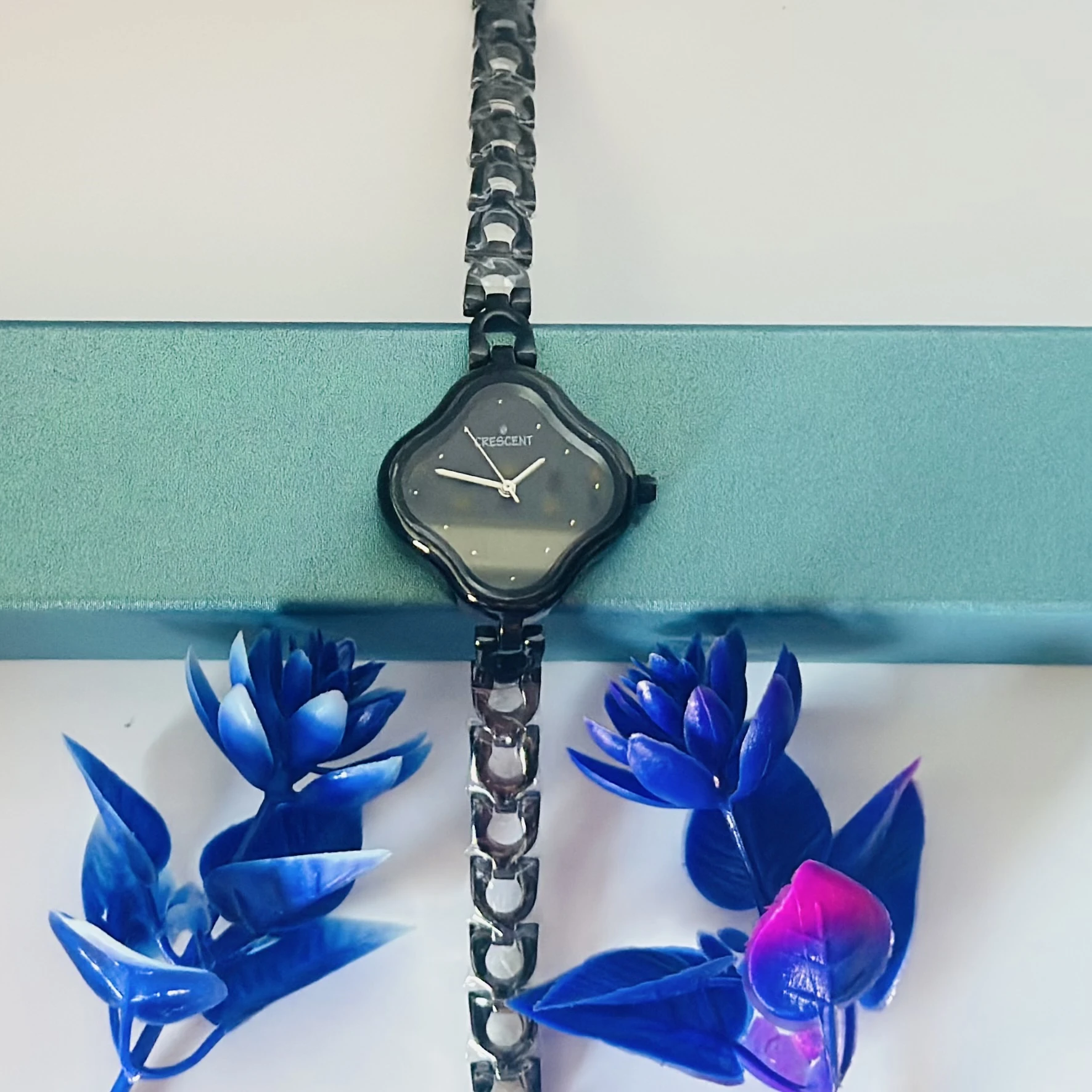 Black dial analog watch for women with a black bi-metal strap.