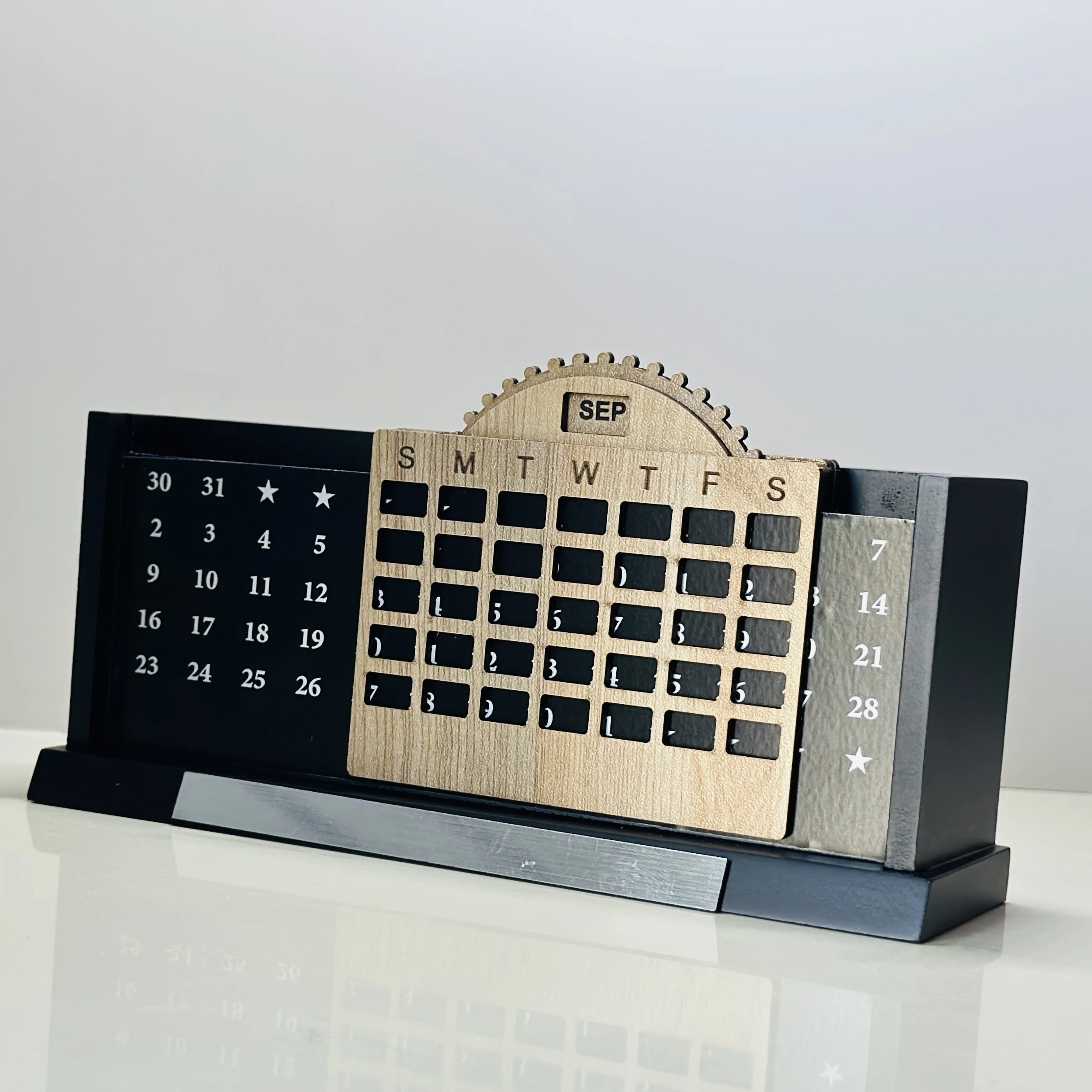 Wooden desk organizer that includes a perpetual calendar and a pen stand.