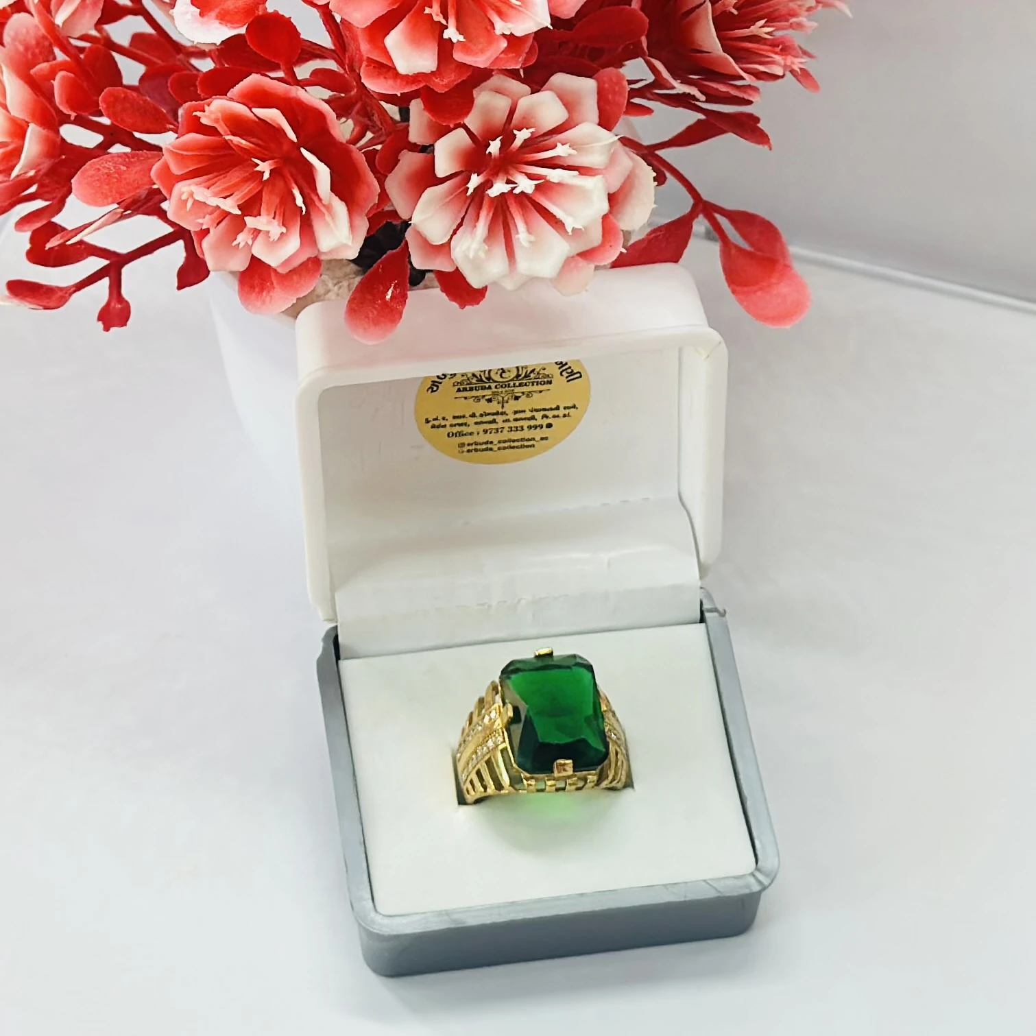 Gold plated men's ring with a green artificial stone and white artificial diamonds.