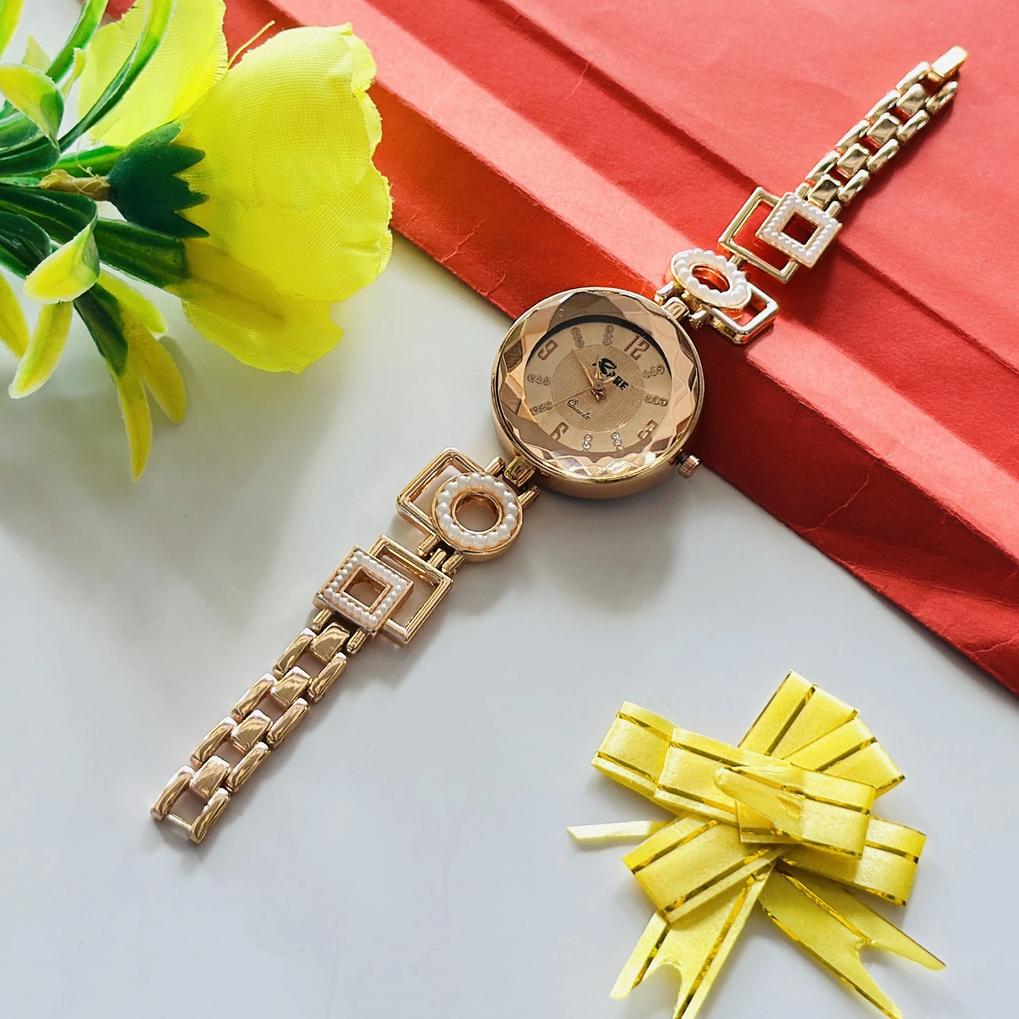 women's analog wristwatch featuring a rose gold-colored chain strap and a stylized dial.