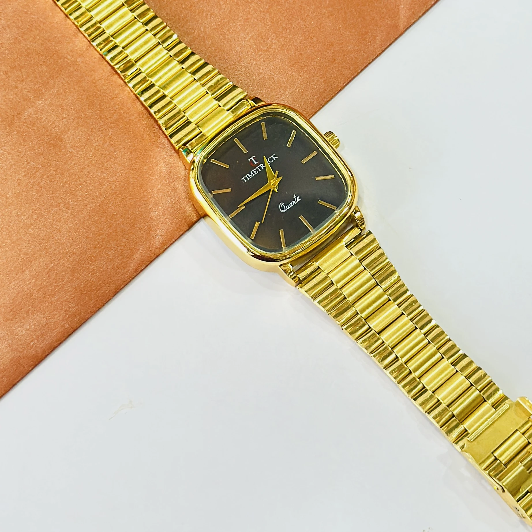 Timetrack quartz watch features a gold-tone stainless steel band and a dark dial.