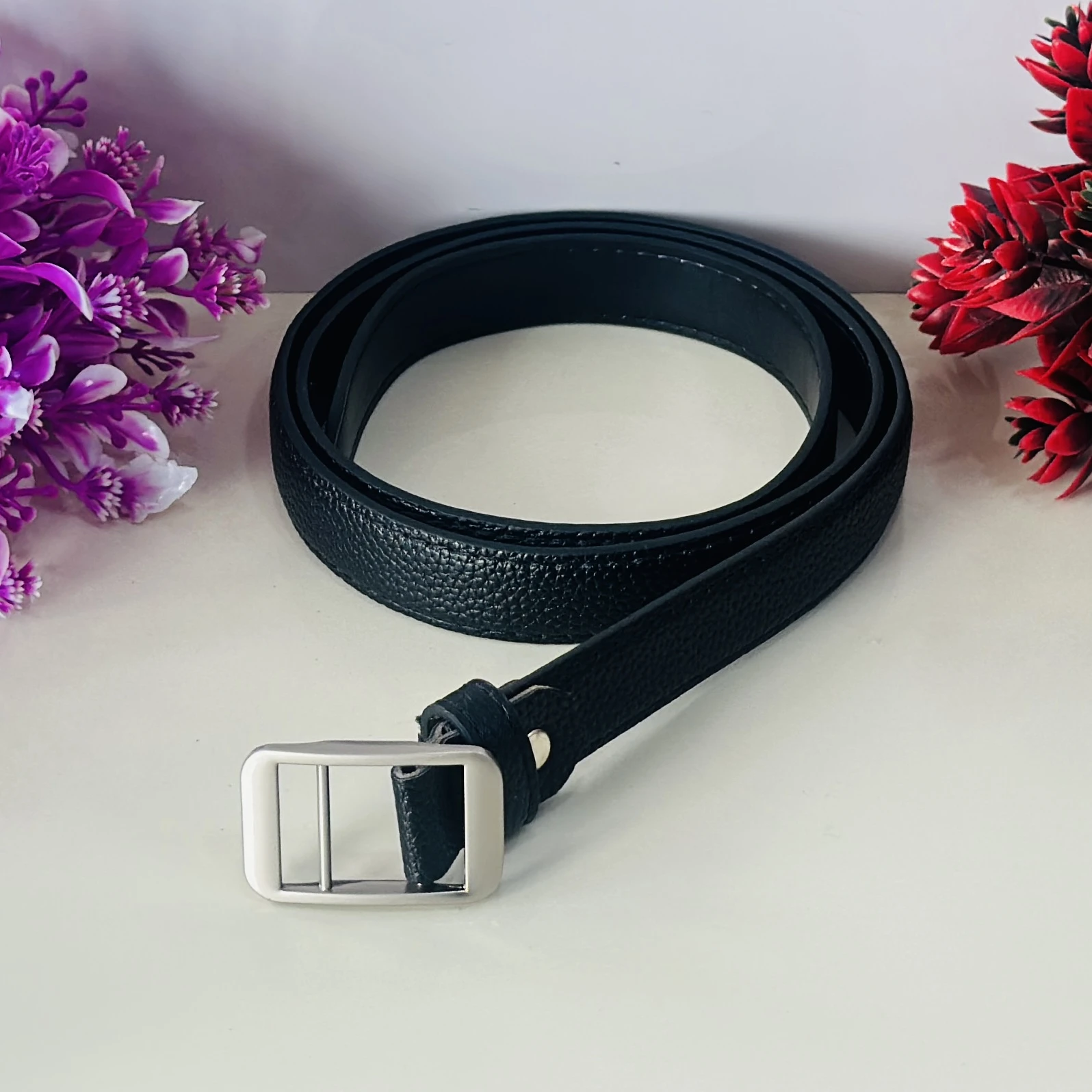 Black leather belt with a metal pin buckle.