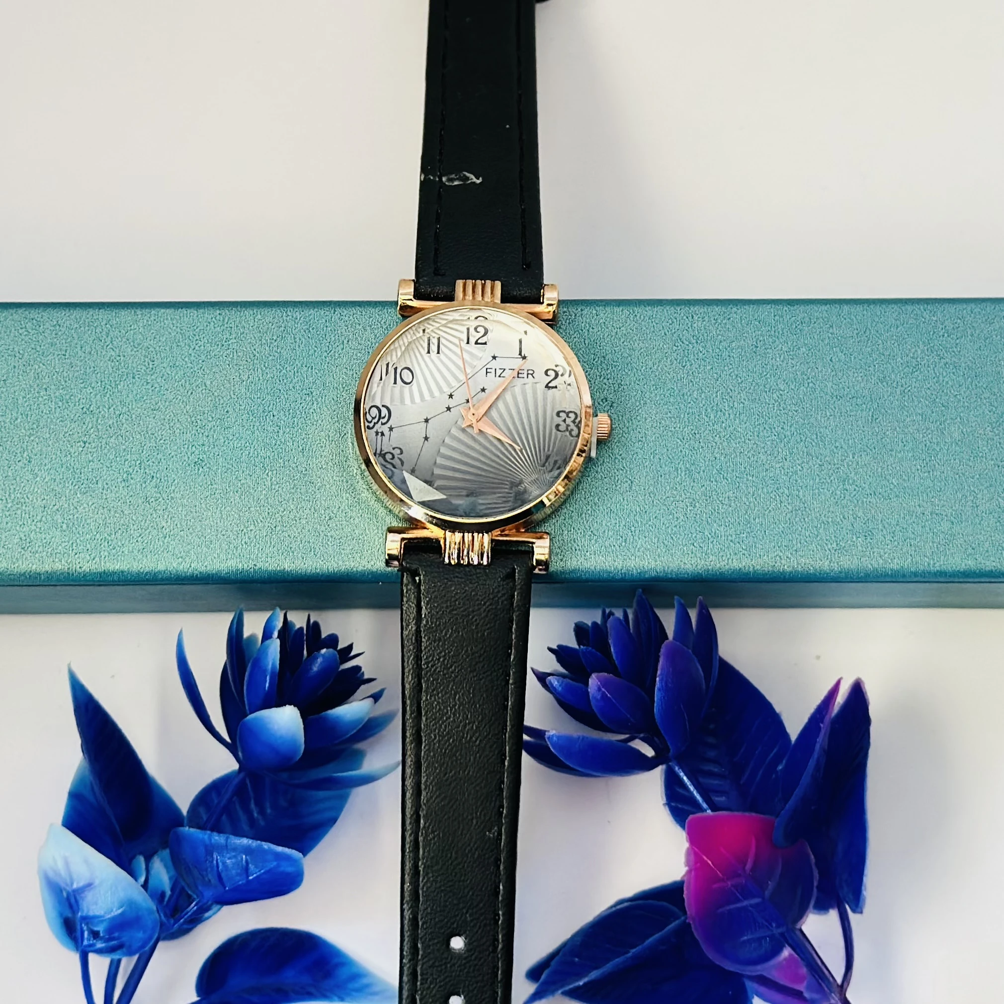 women's analog watch with a black leather strap and a rose gold-toned case.