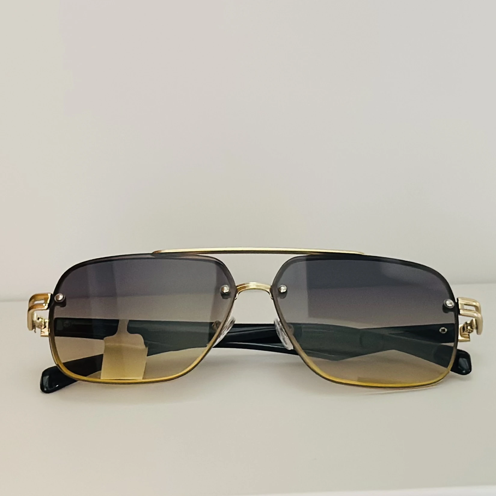 square aviator sunglasses with a gold-toned metal frame and brown gradient lenses