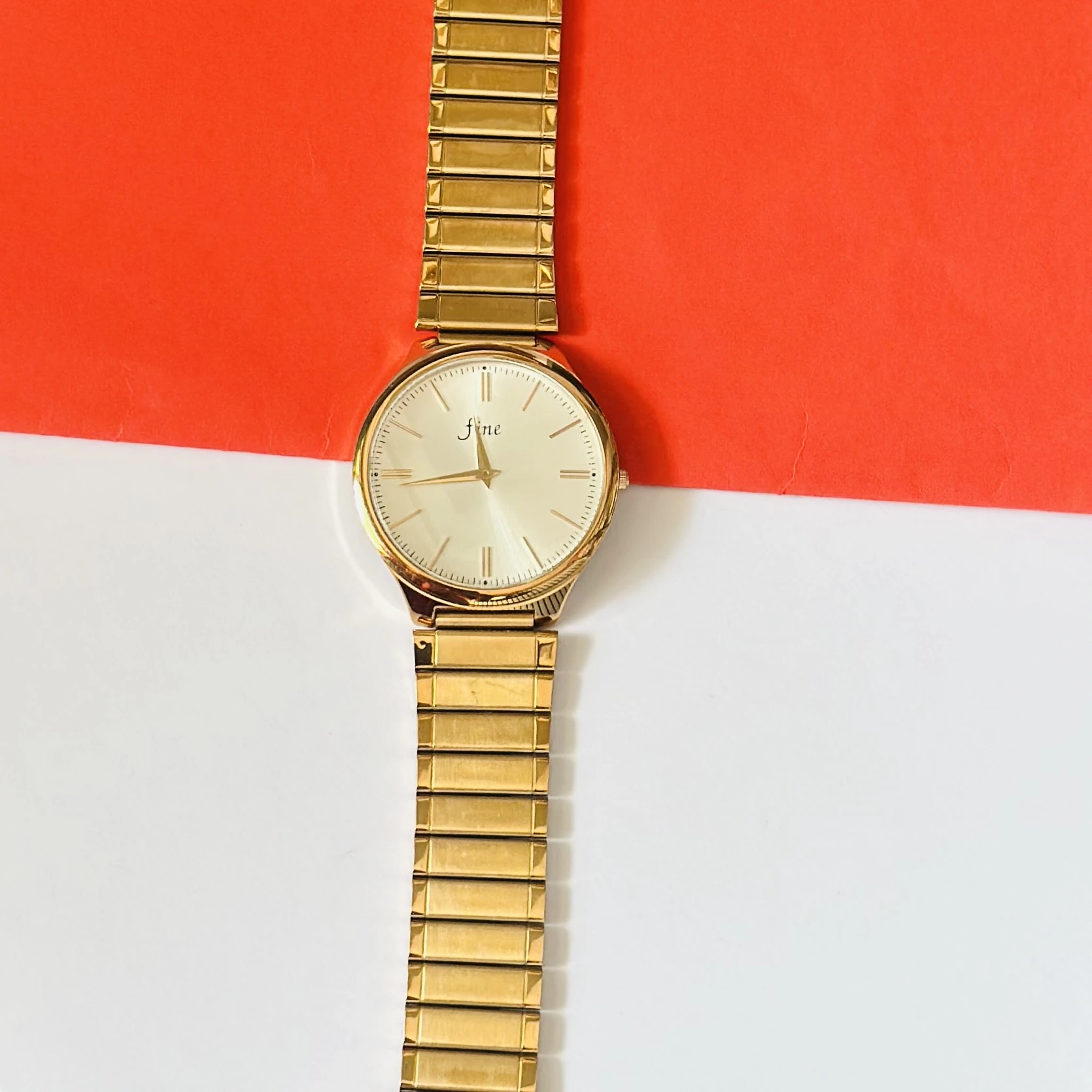 Gold toned analog watch with a stainless steel strap