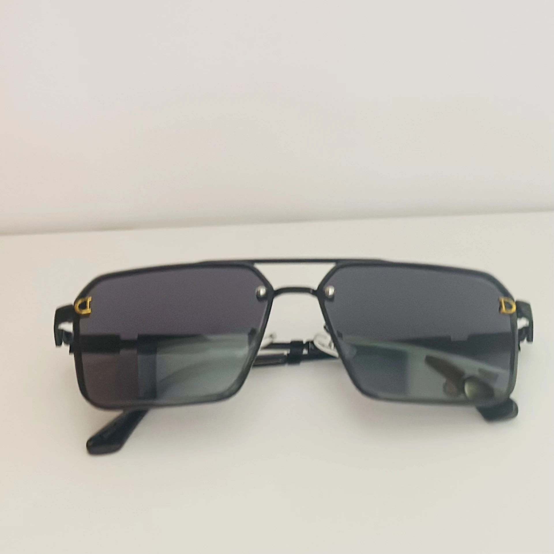 black pilot-style sunglasses with grey polycarbonate lenses.