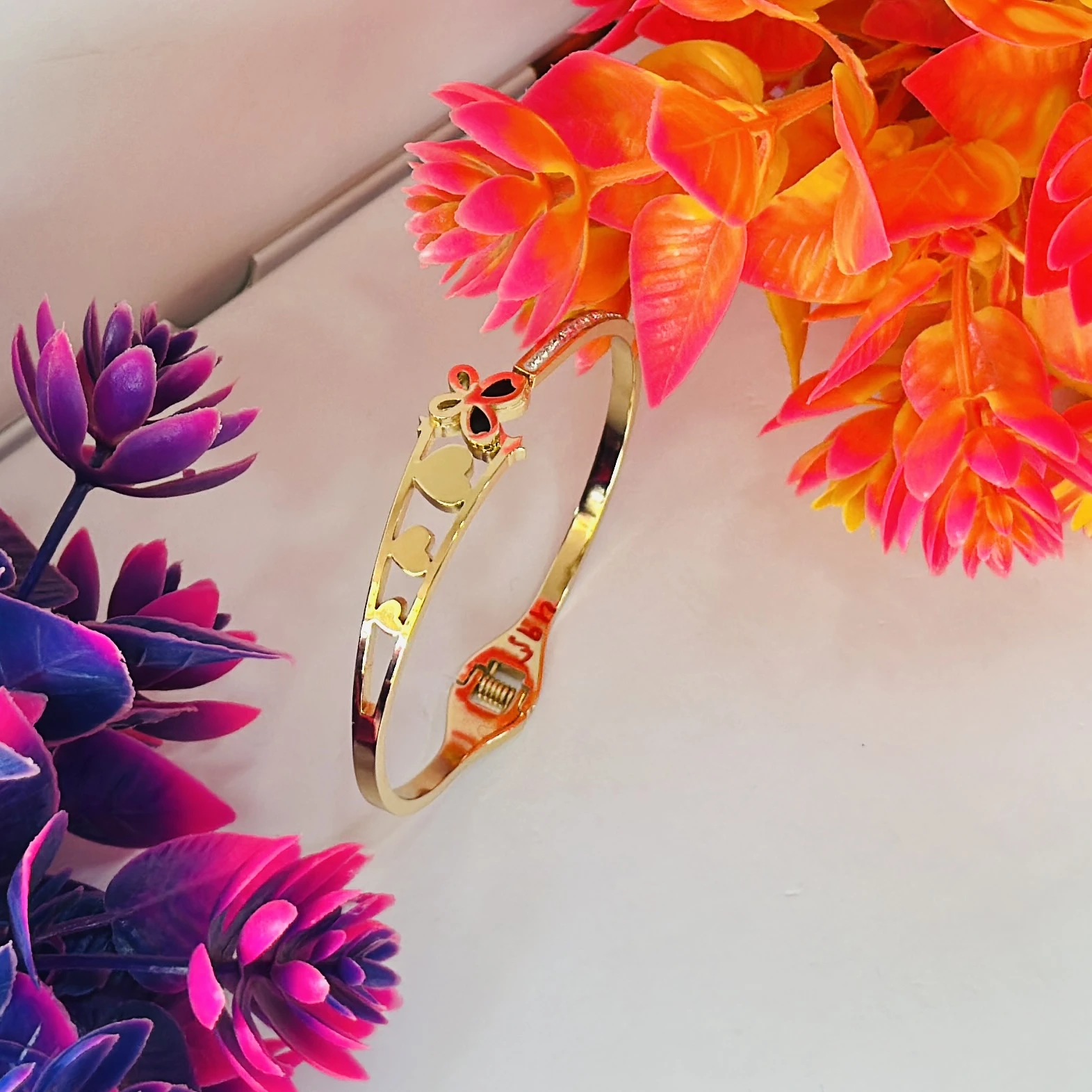Gold plated bangle bracelet with a butterfly and heart design
