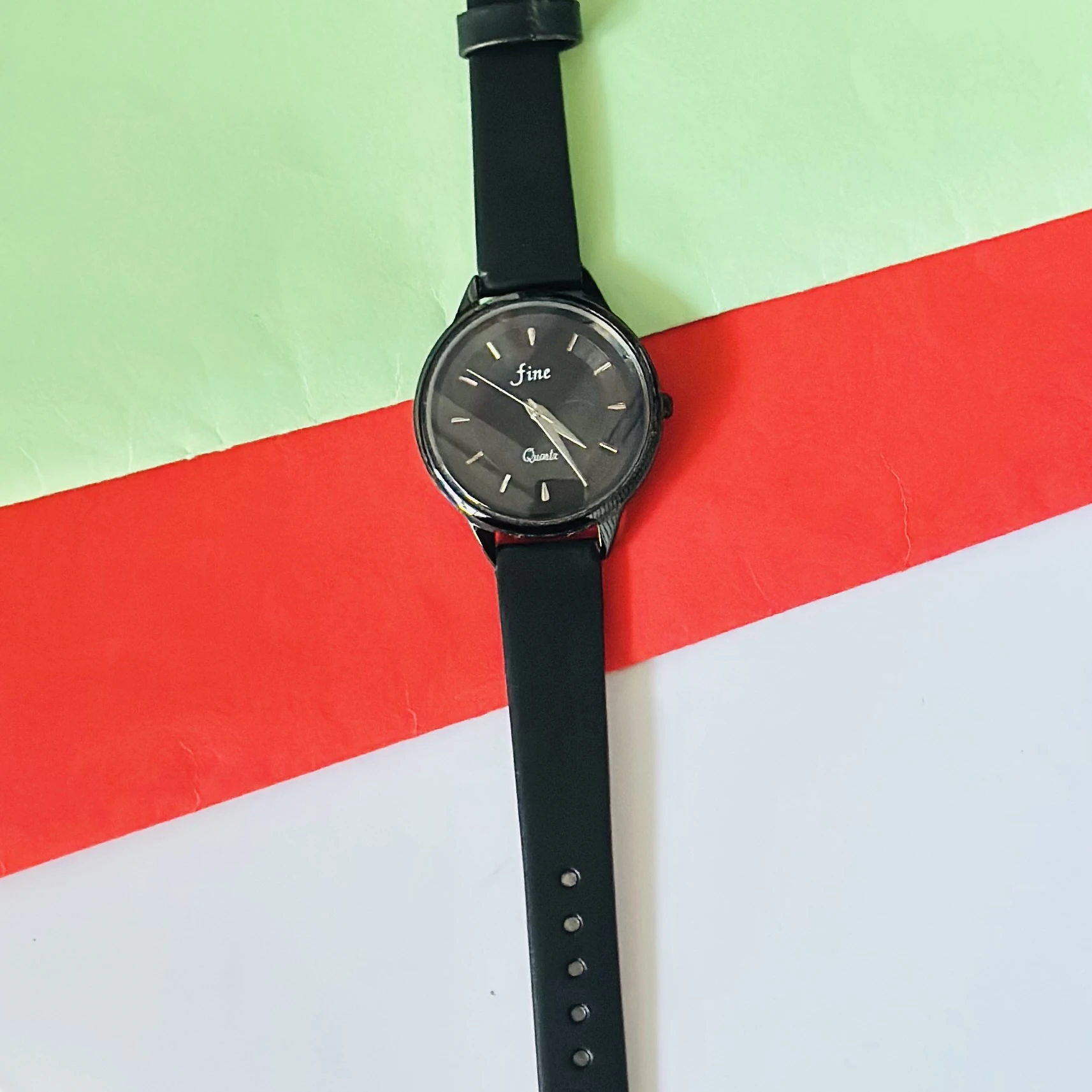 Black analog quartz wrist watch with a black strap.