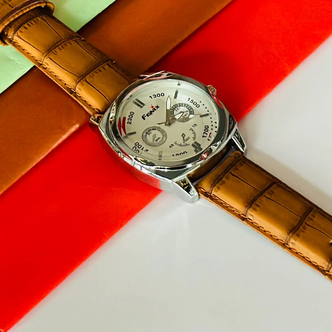 Round analog watch with a brown leather strap
