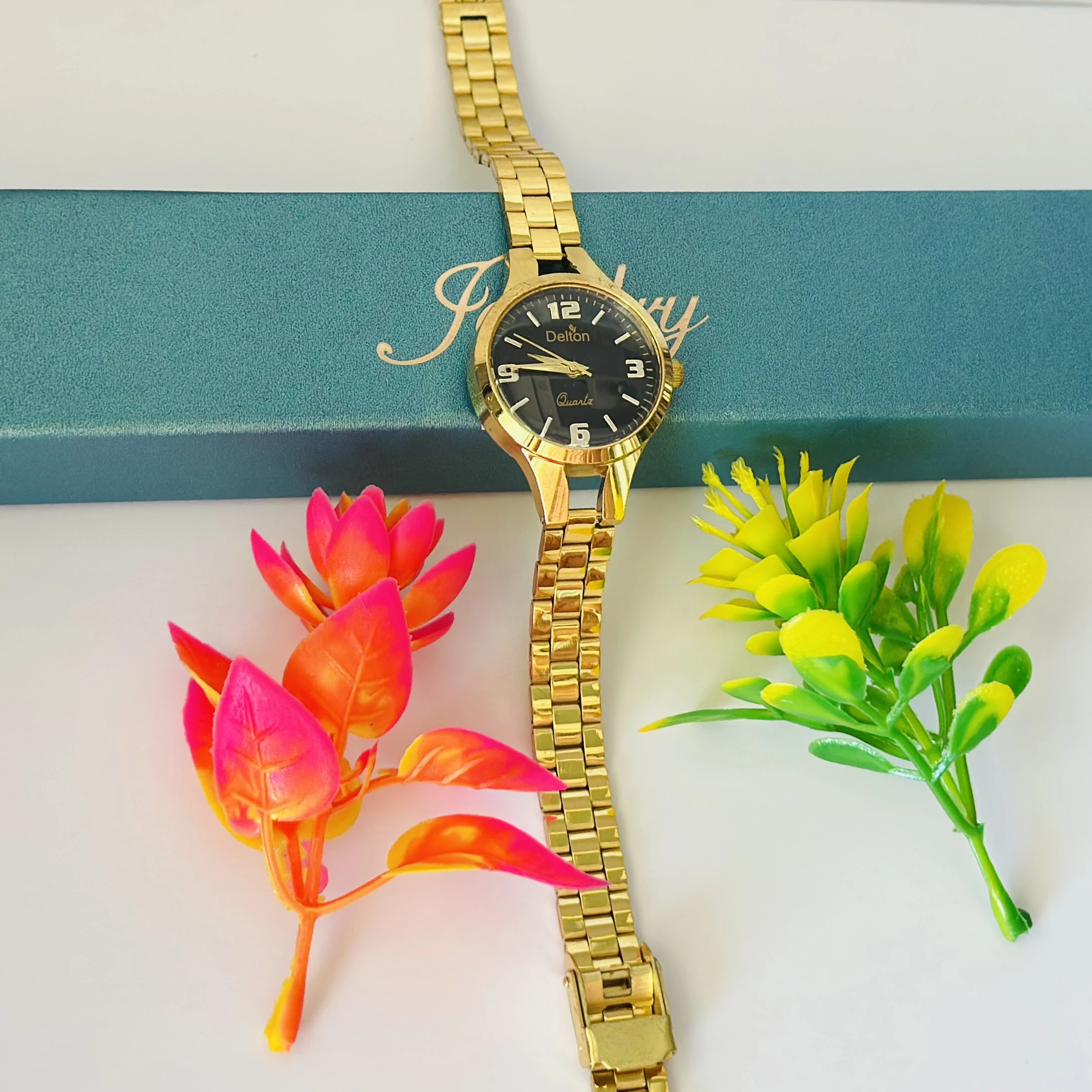 Analog quartz watch with a black dial and a gold-tone stainless steel strap.