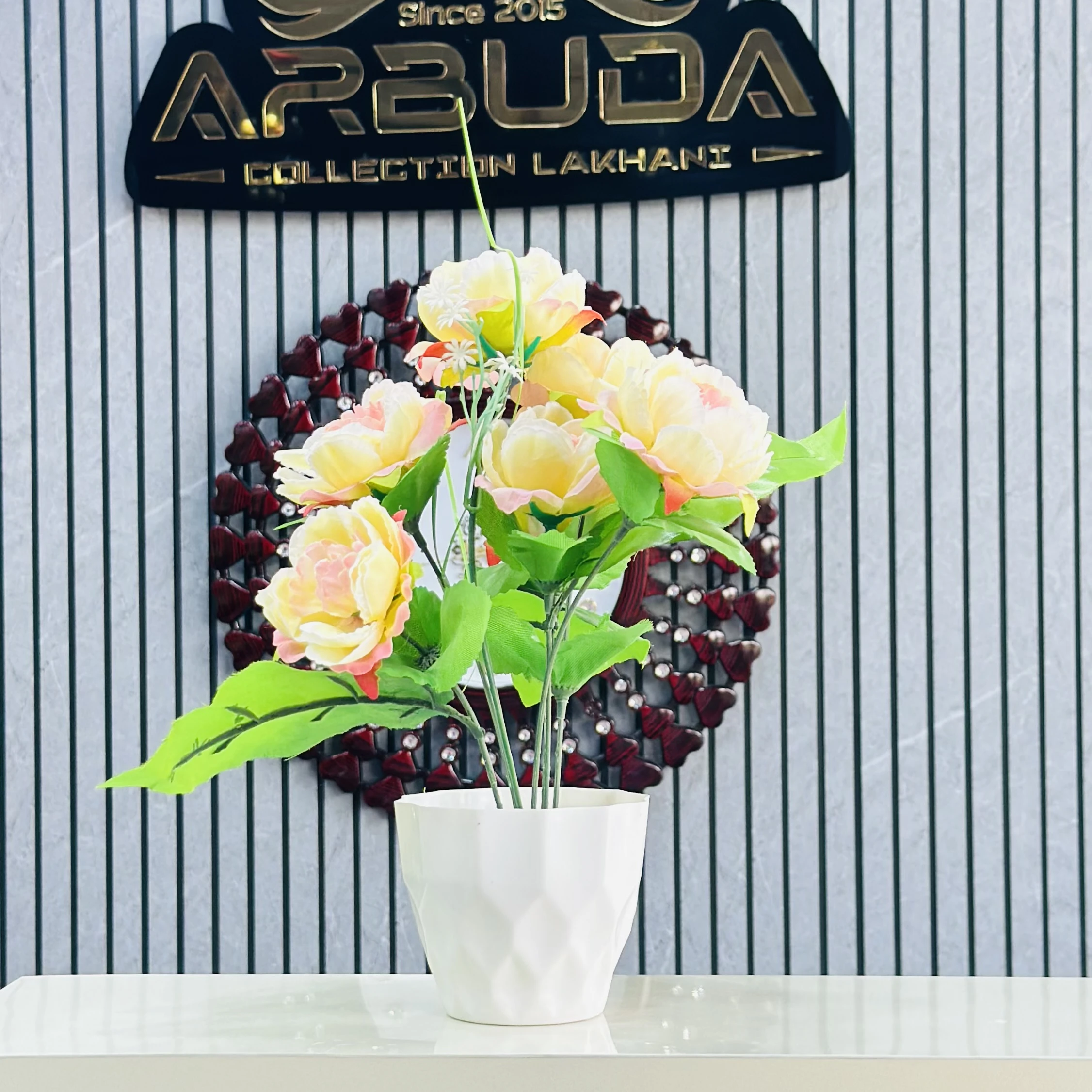 An artificial flower arrangement in a white ceramic pot.