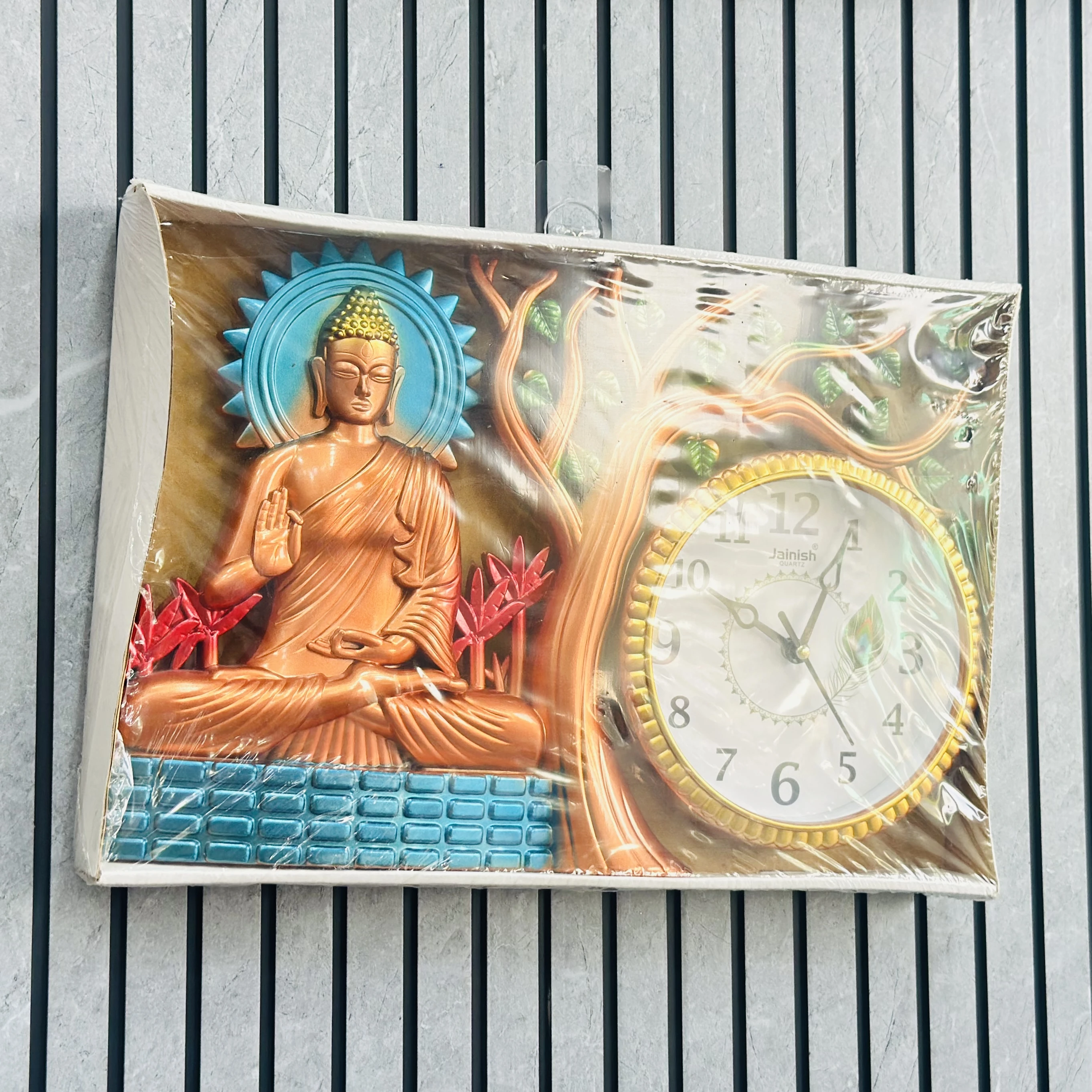 Wall clock featuring a depiction of Buddha under a tree.