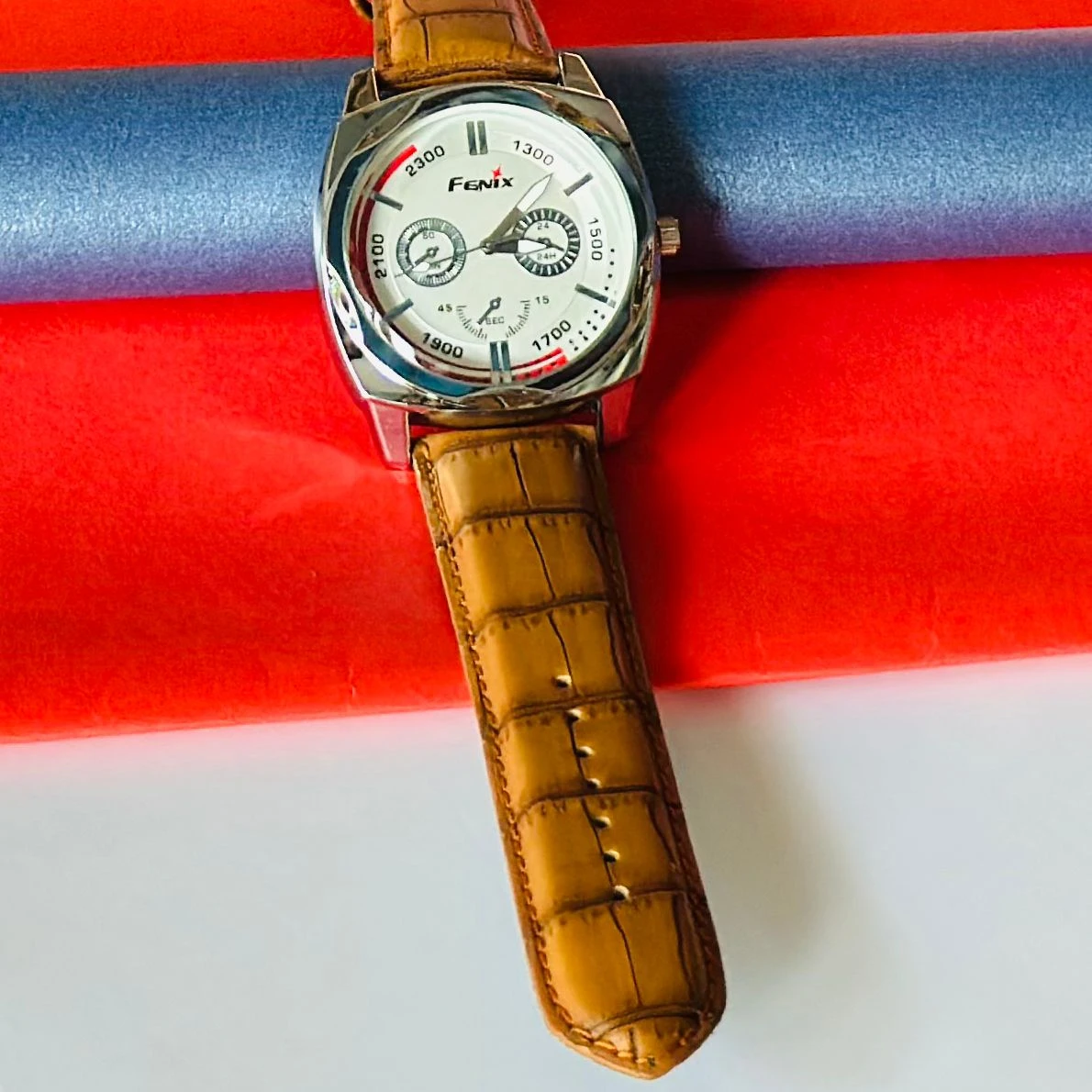 Round analog watch with a brown leather strap
