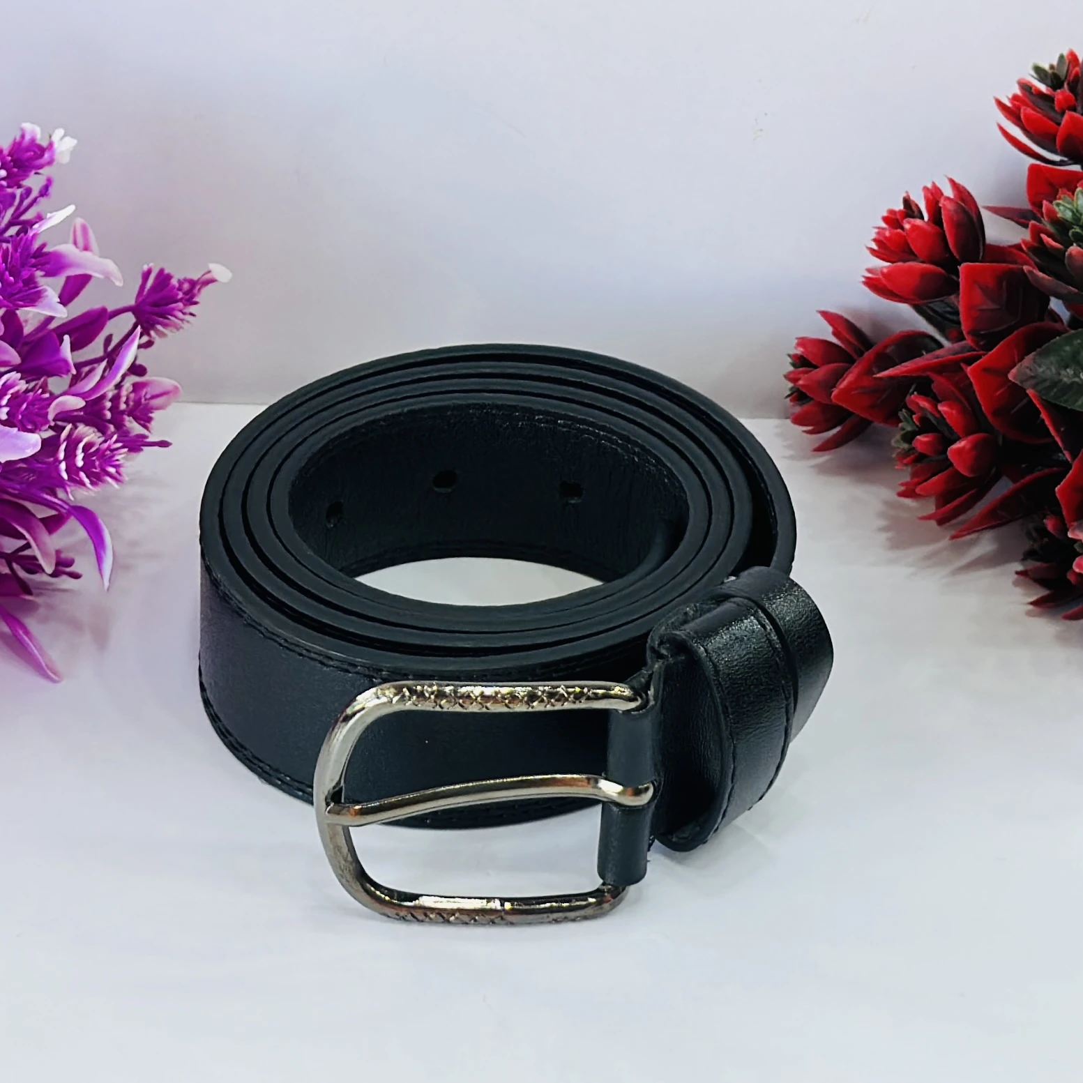 Men’s black leather belt with a metal buckle.