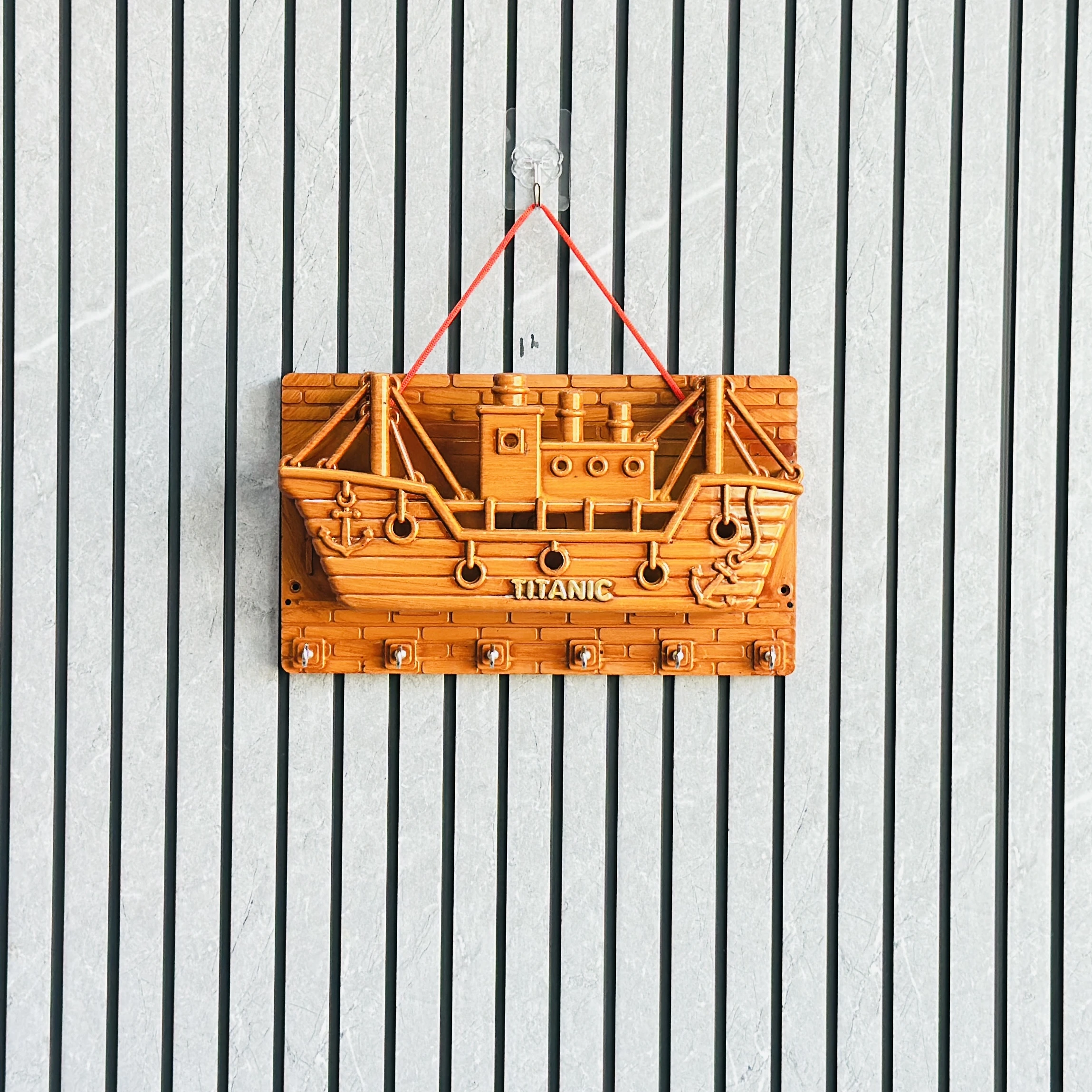 wooden wall-mounted key holder (BRYTZG )shaped like a ship labeled "TITANIC".