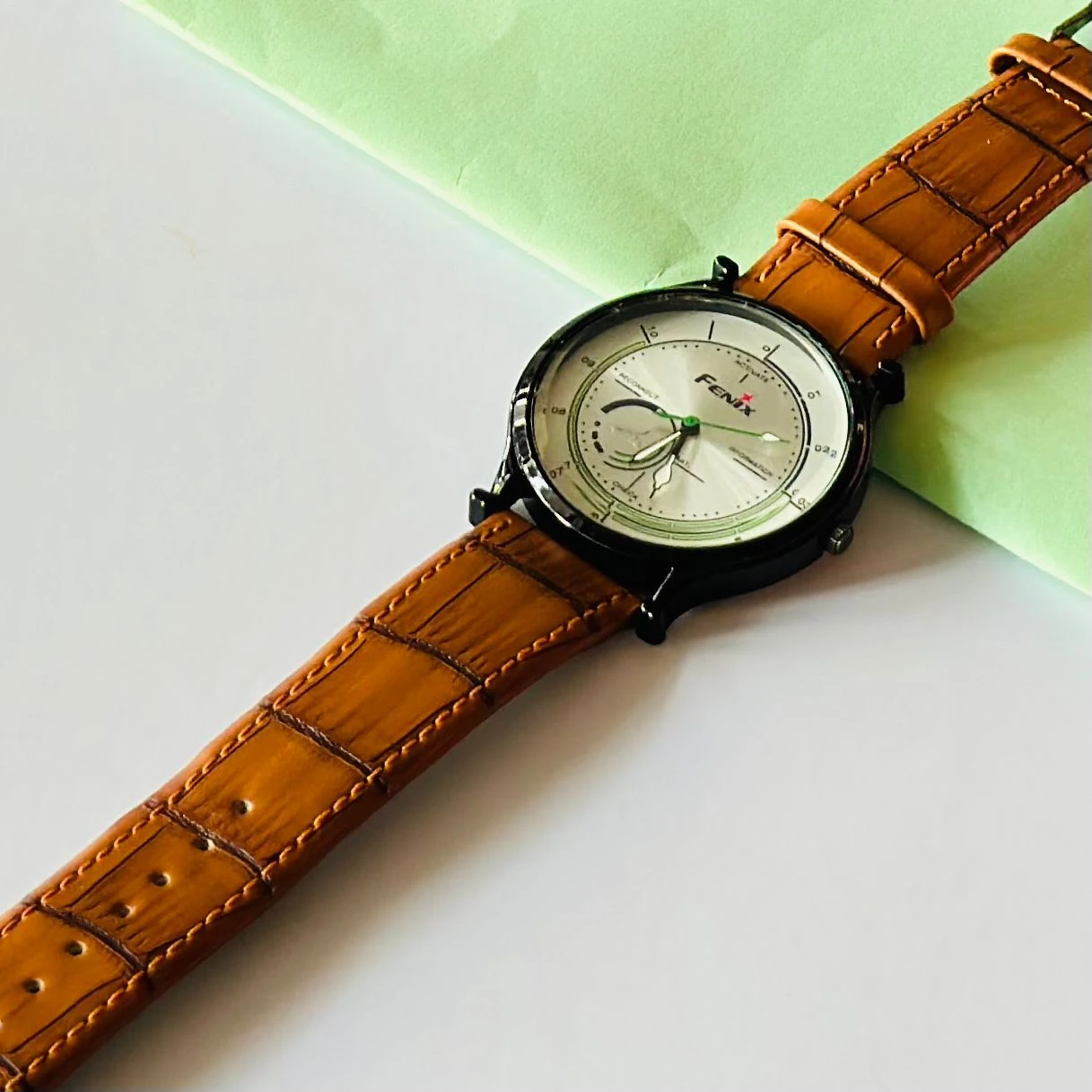 Round  analog watch with a brown leather strap