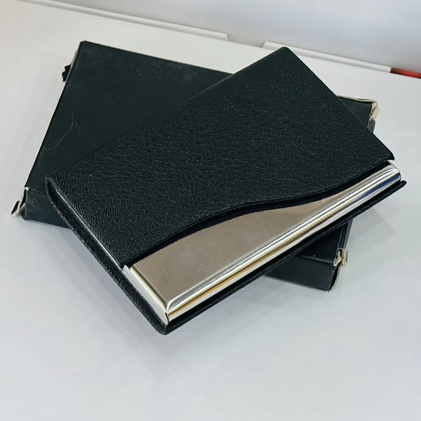 black faux leather and metal business card holder.
