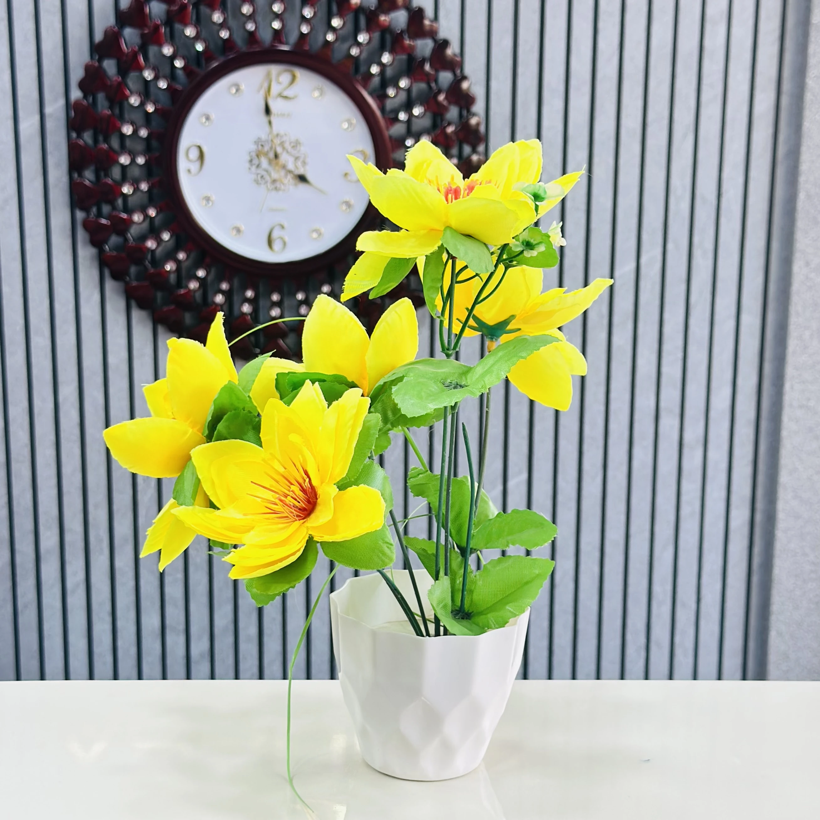 Yellow lily flower plant in a white pot.