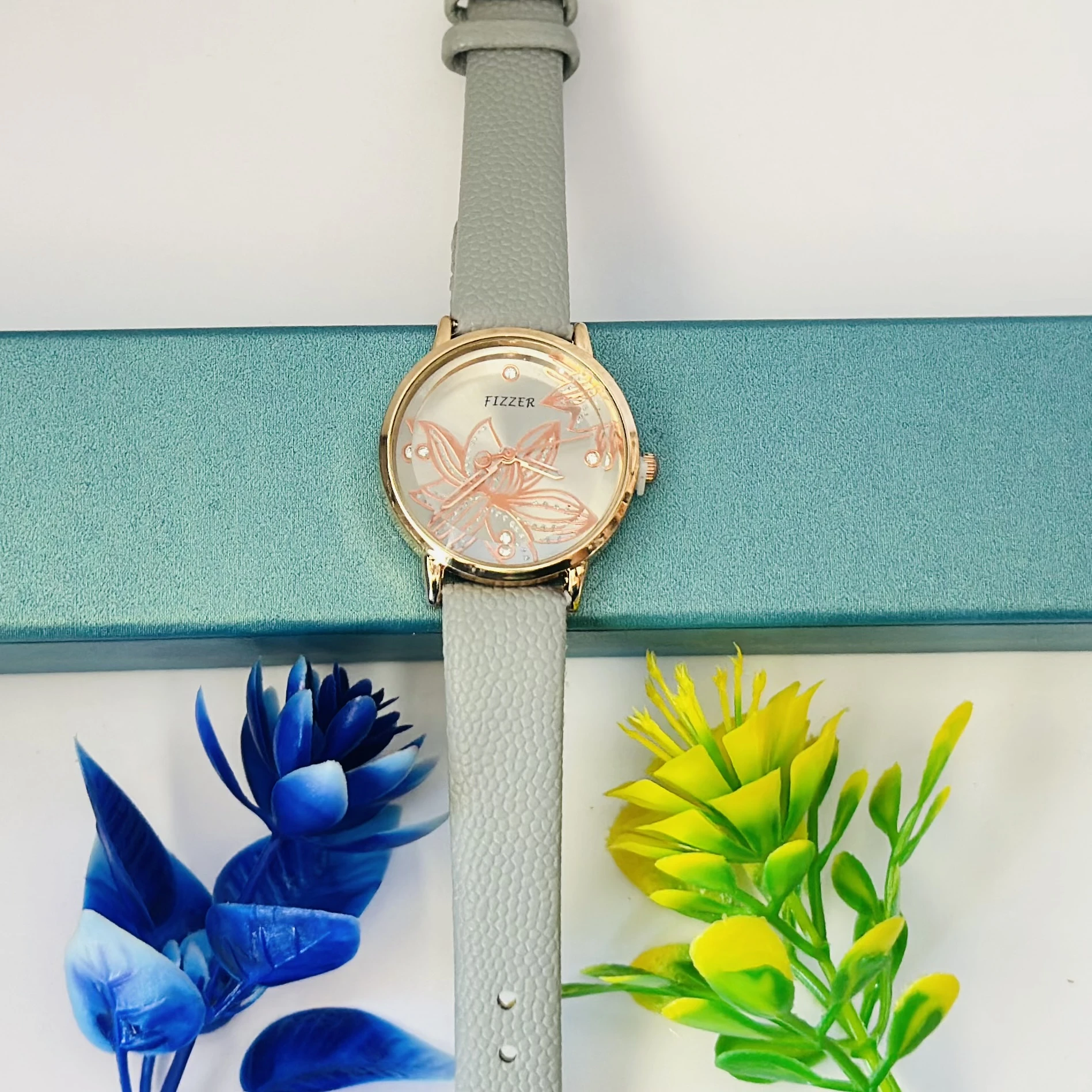 Fizzer women's analog watch with a grey leather strap and a floral-printed dial.