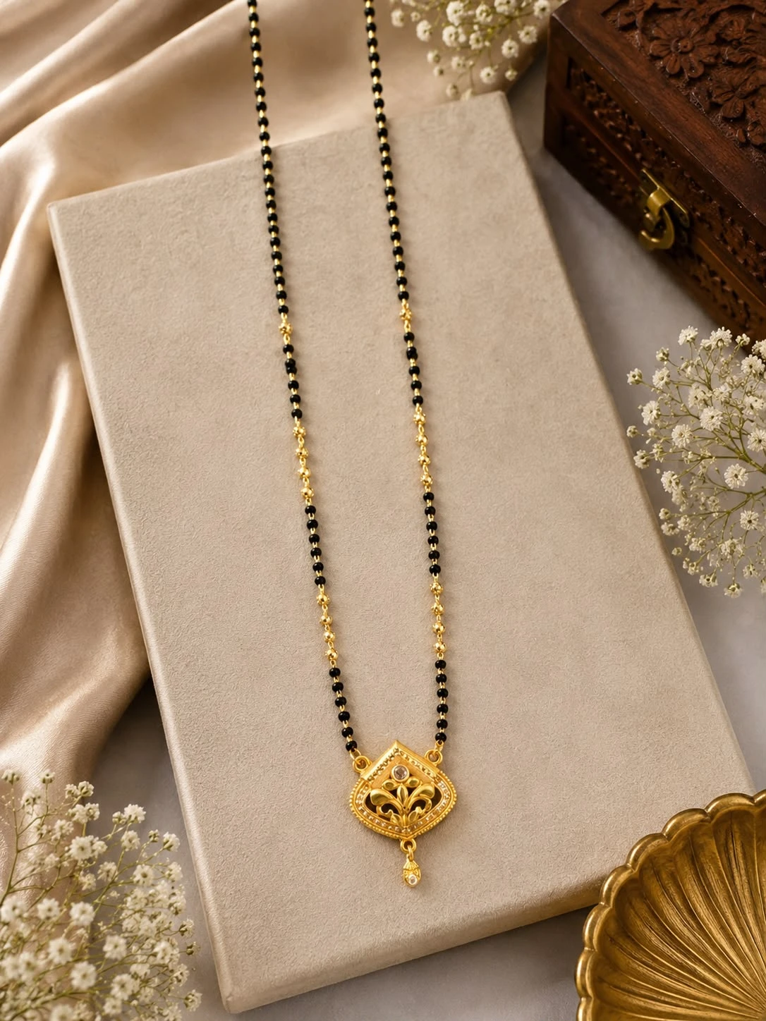 gold-plated brass mangalsutra features a diamond-studded filigree pendant