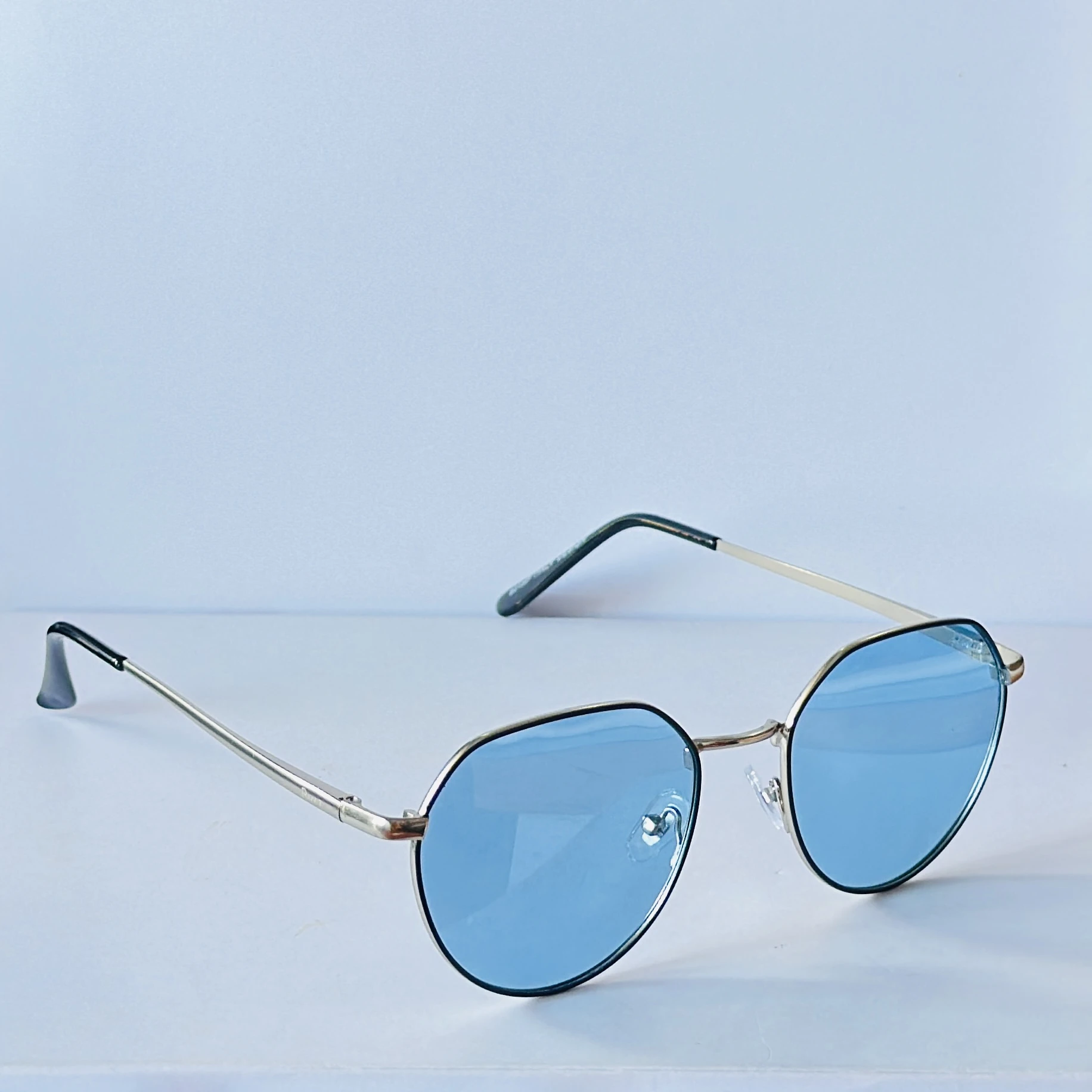 sunglasses appear to be the IRUS S1133 Hexagonal model with a silver frame and blue lenses.
