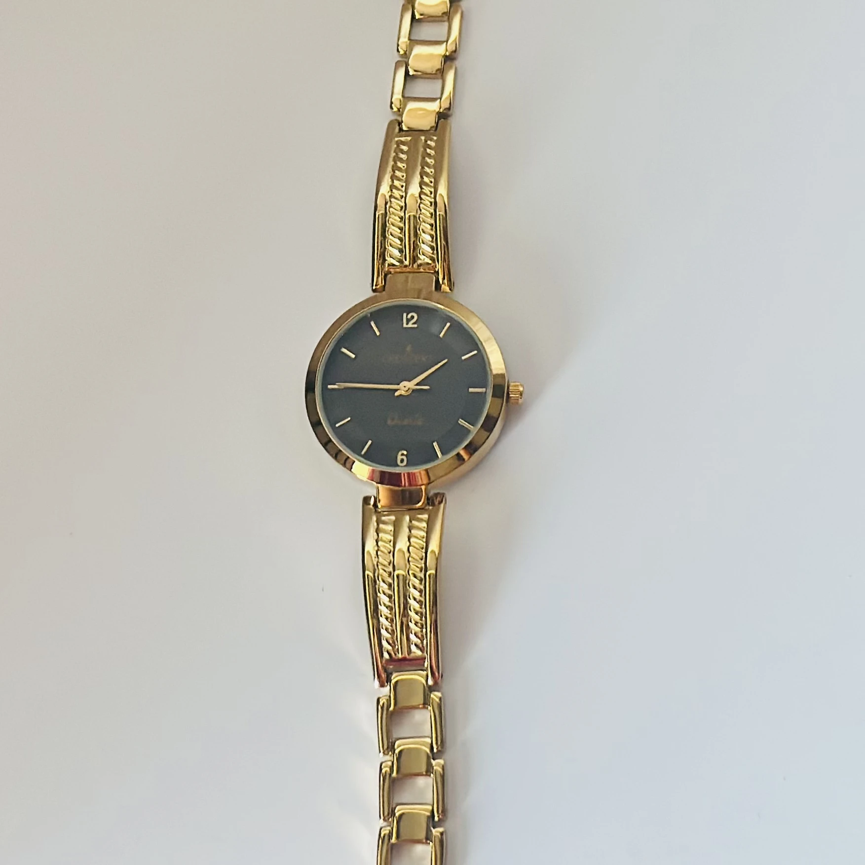 Anne Klein black dial gold-tone and black resin ladies watch.