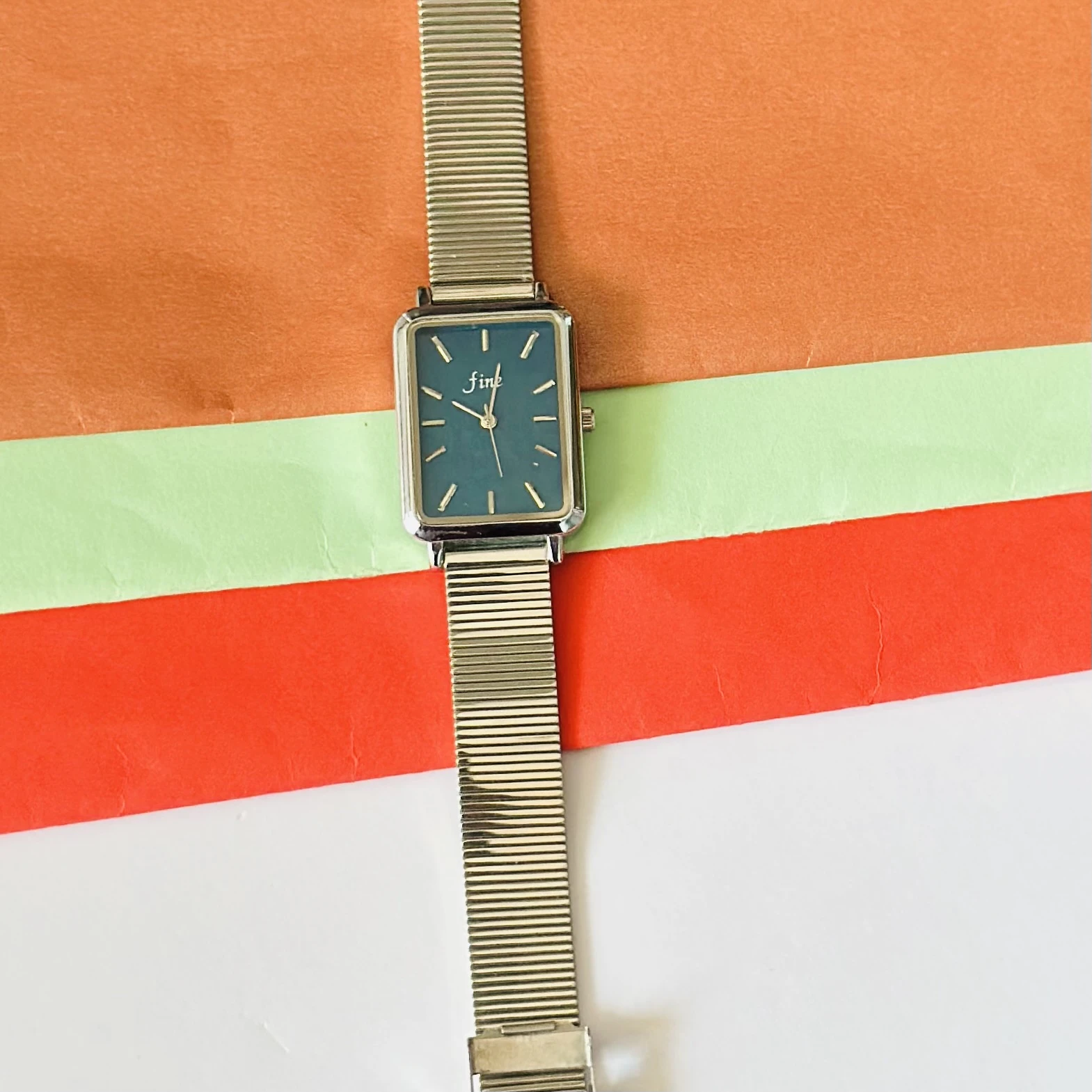 Rectangular Dial analog watch with a mesh strap.
