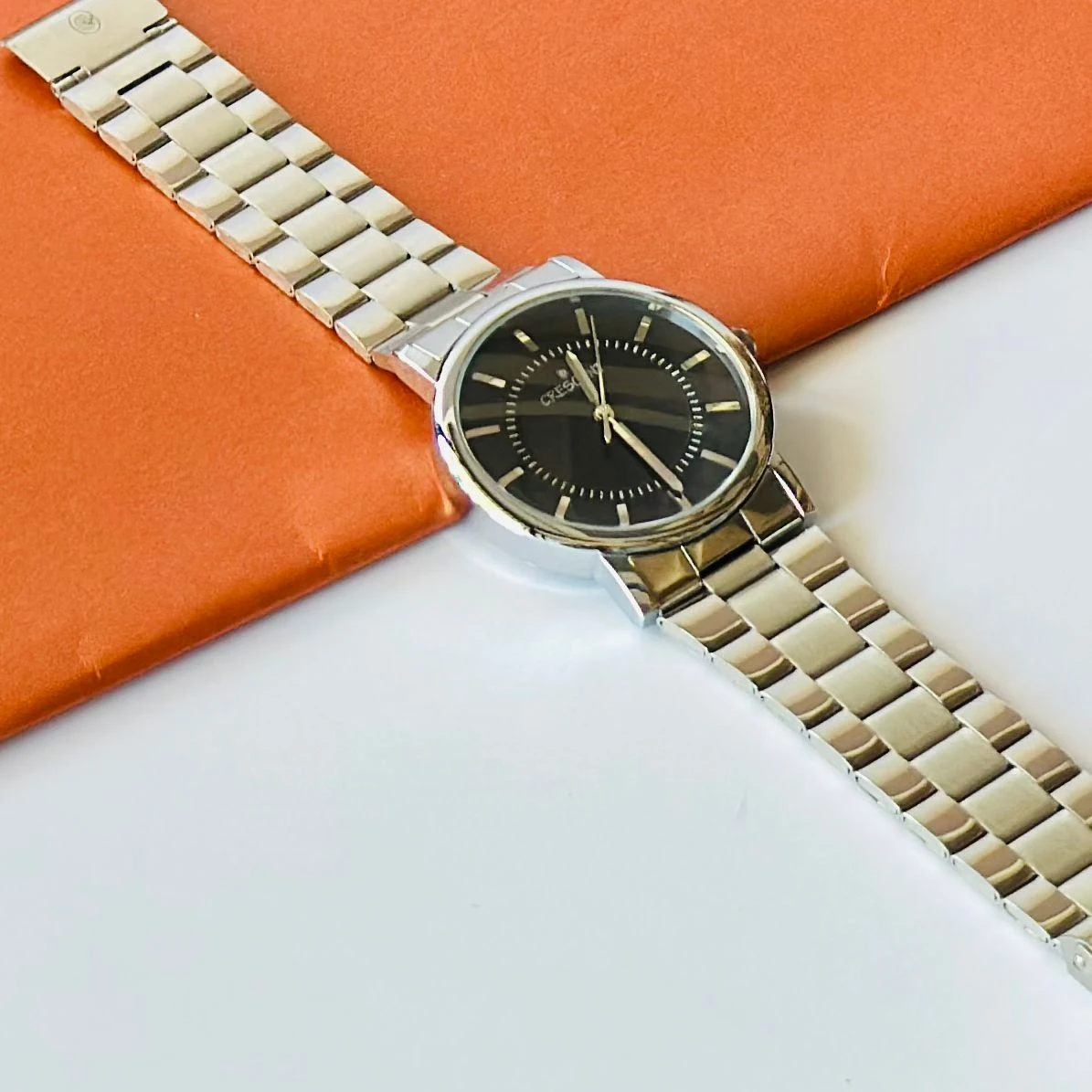 Crescent analog watch with a black dial and a silver stainless steel band