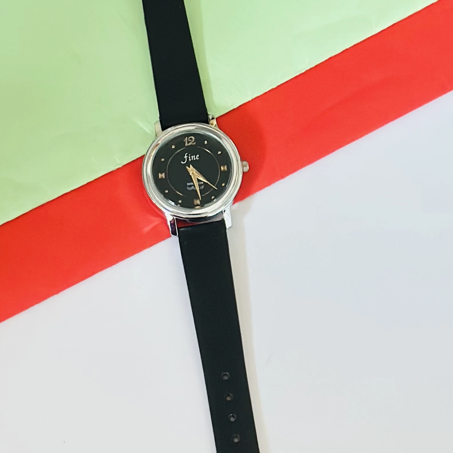 Black analog watch with a black strap.