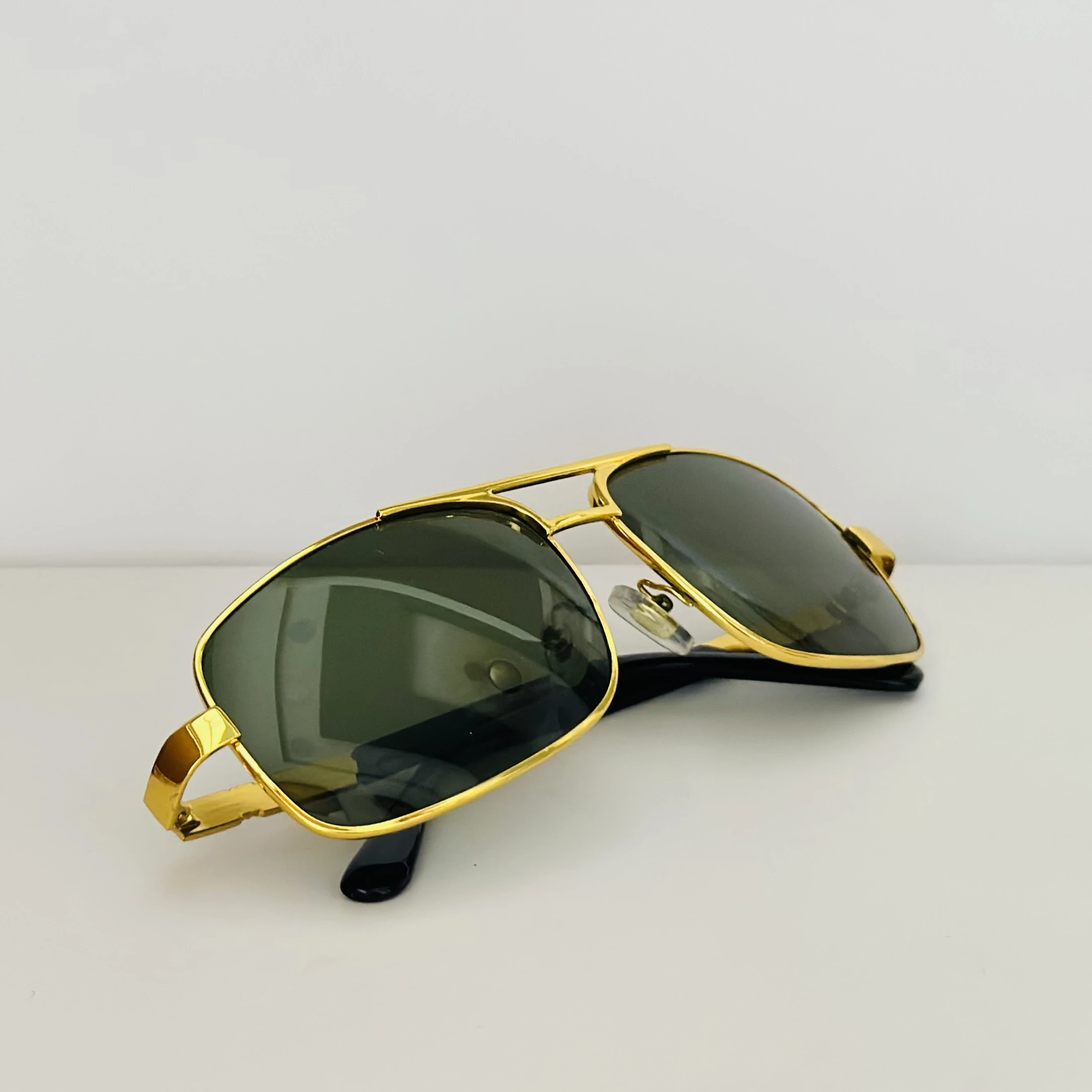 Gold aviator-style sunglasses with green lenses.