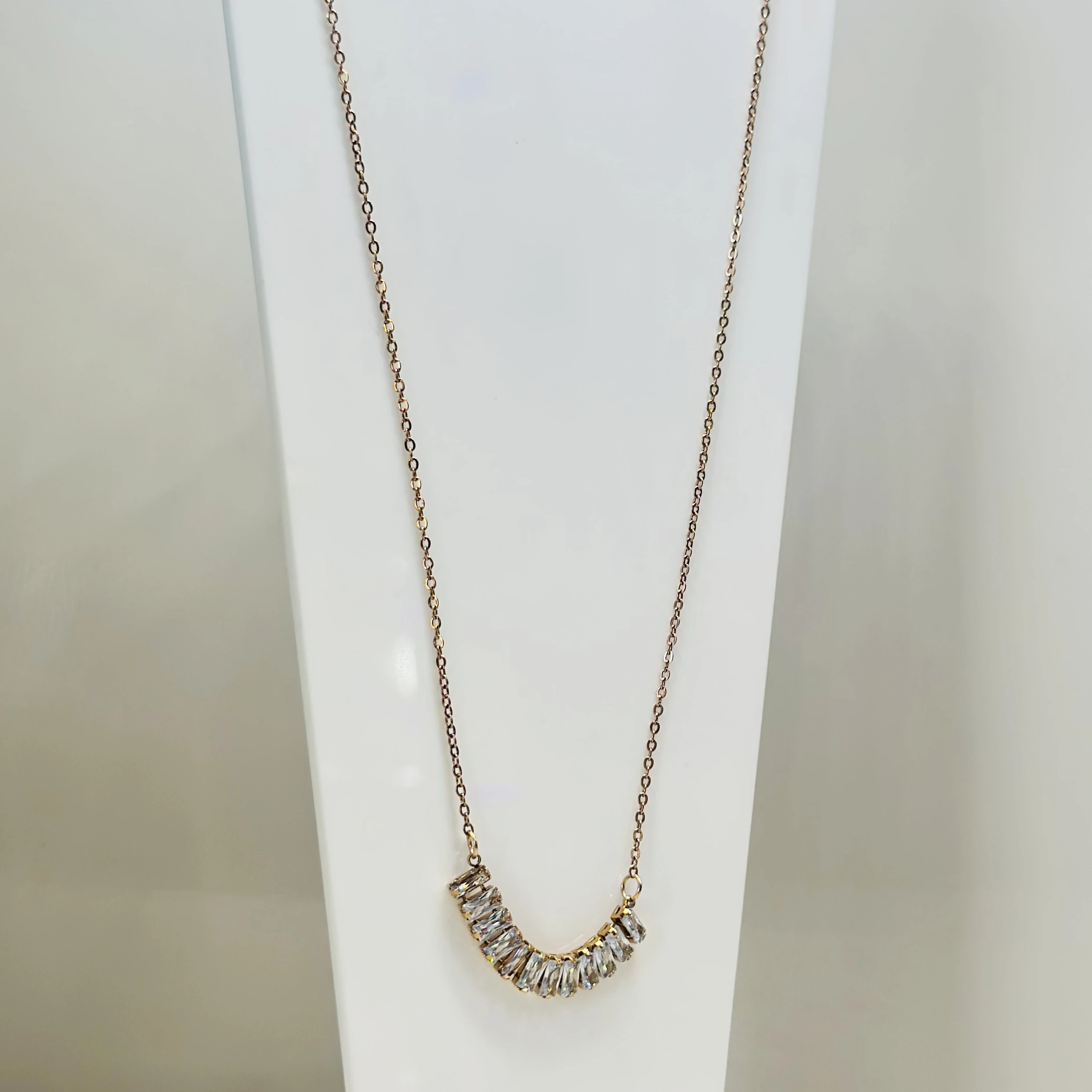 Gold  tone necklace with a curved pendant