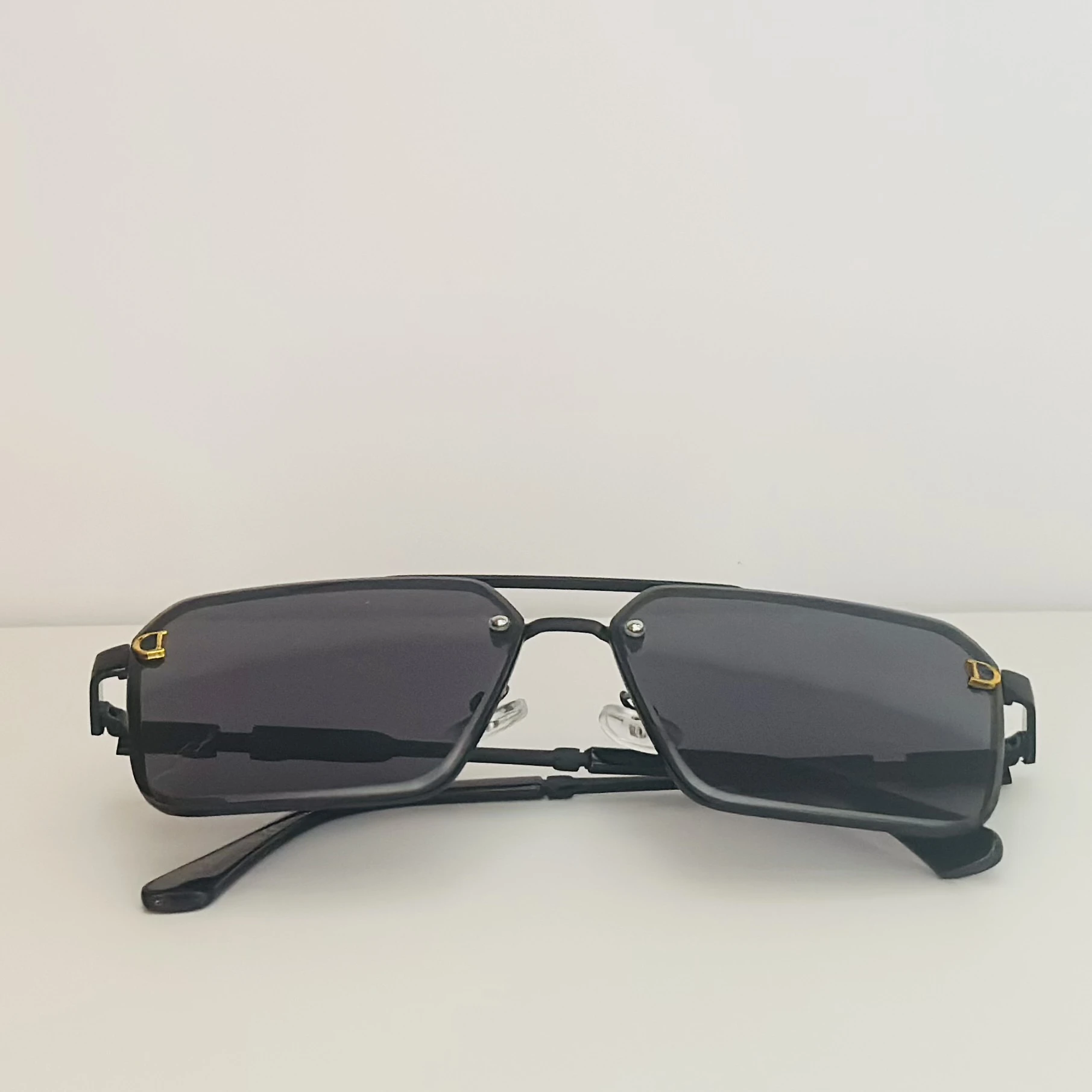 black pilot-style sunglasses with grey polycarbonate lenses.