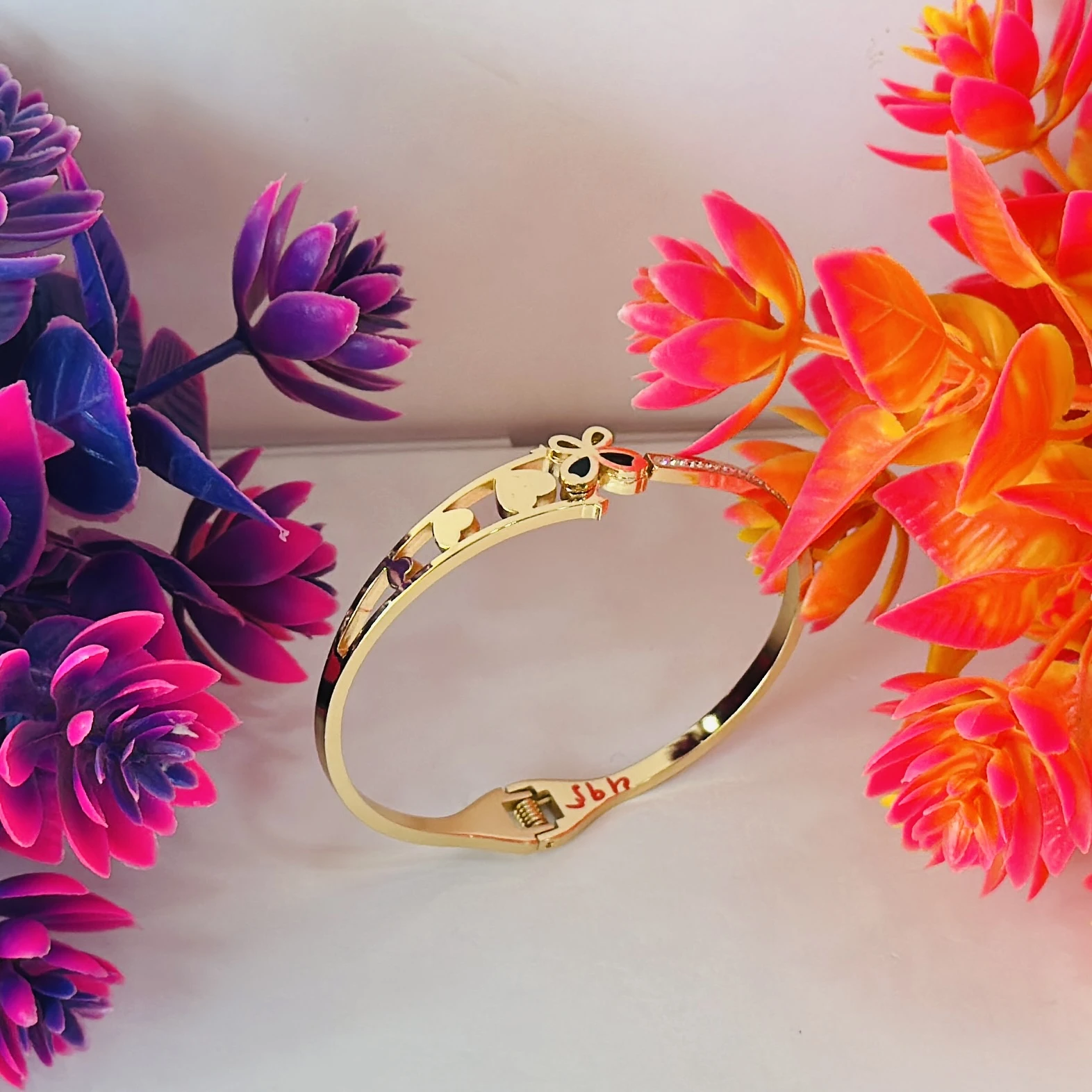 Gold plated bangle bracelet with a butterfly and heart design