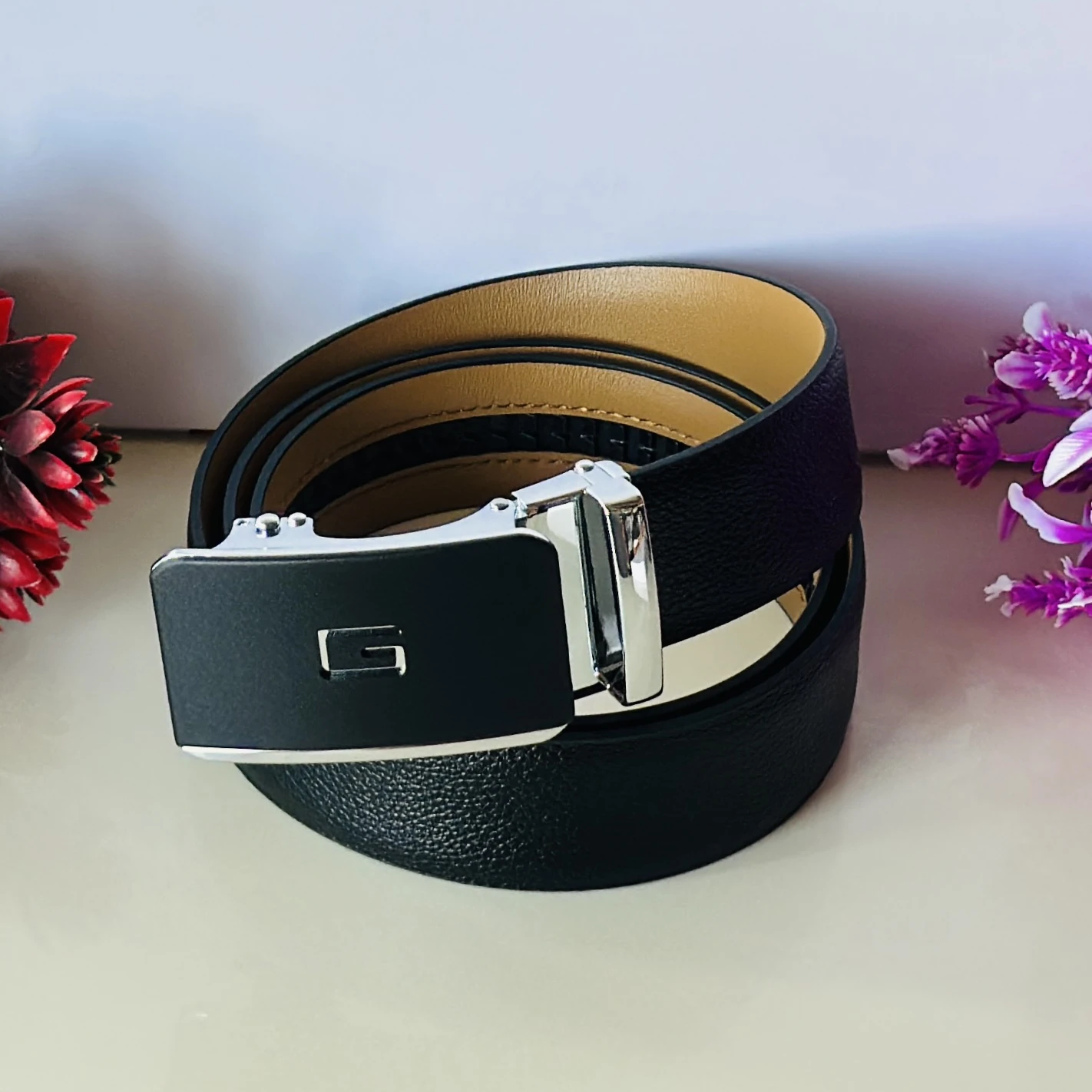 Black leather belt with an automatic/ratchet buckle.