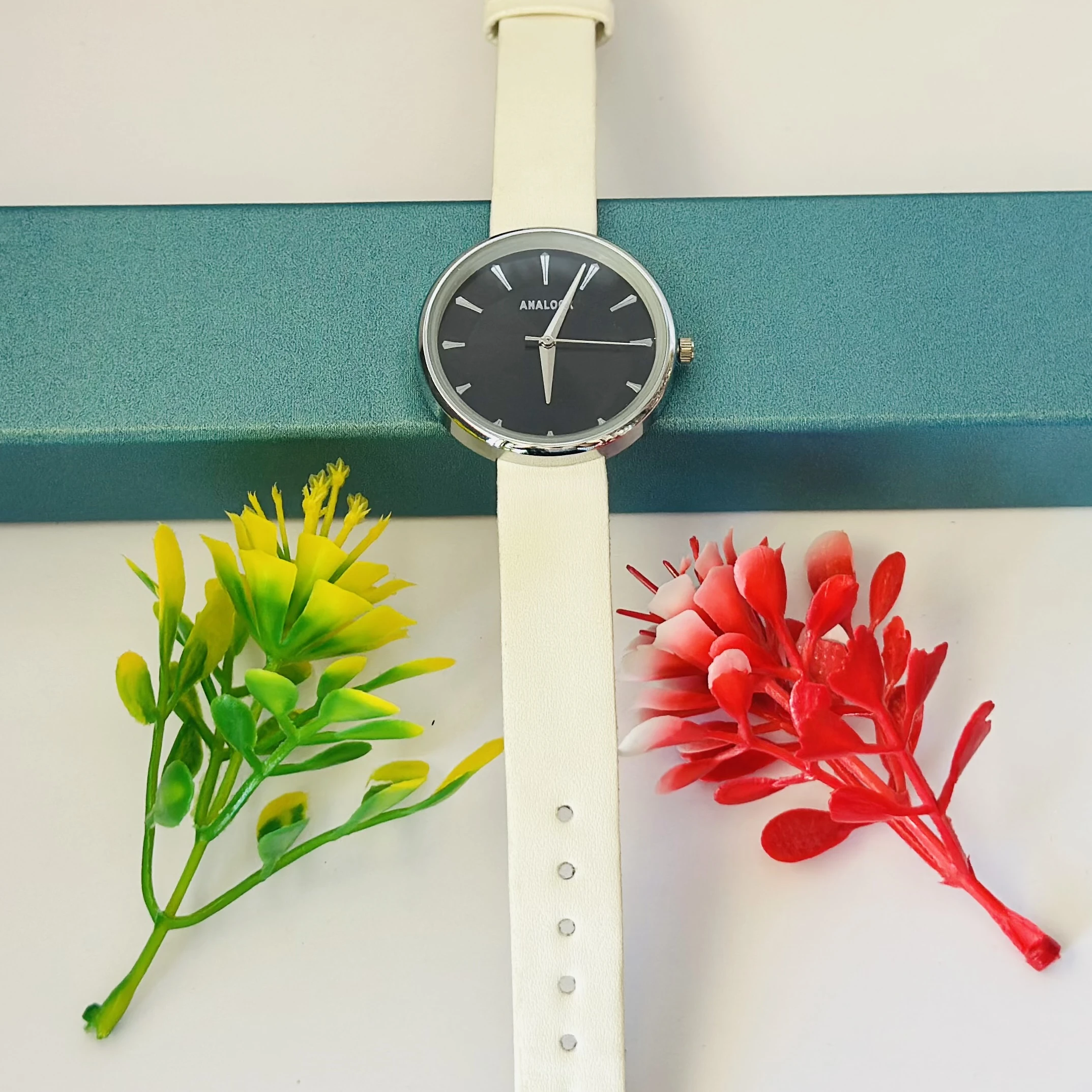 Analogue watch with a black face and a white band.