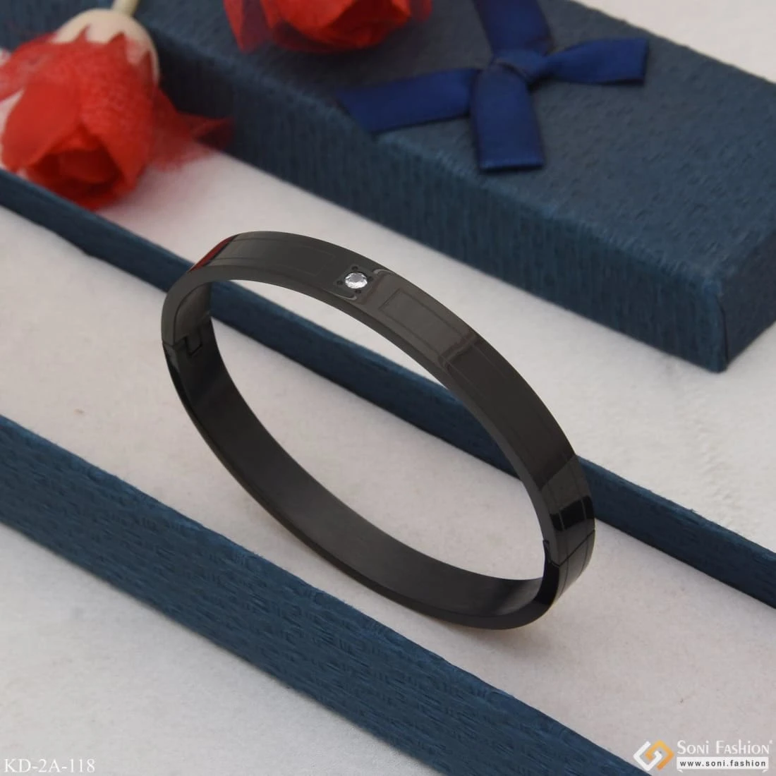 Black stainless steel kada bracelet with a single crystal accent.