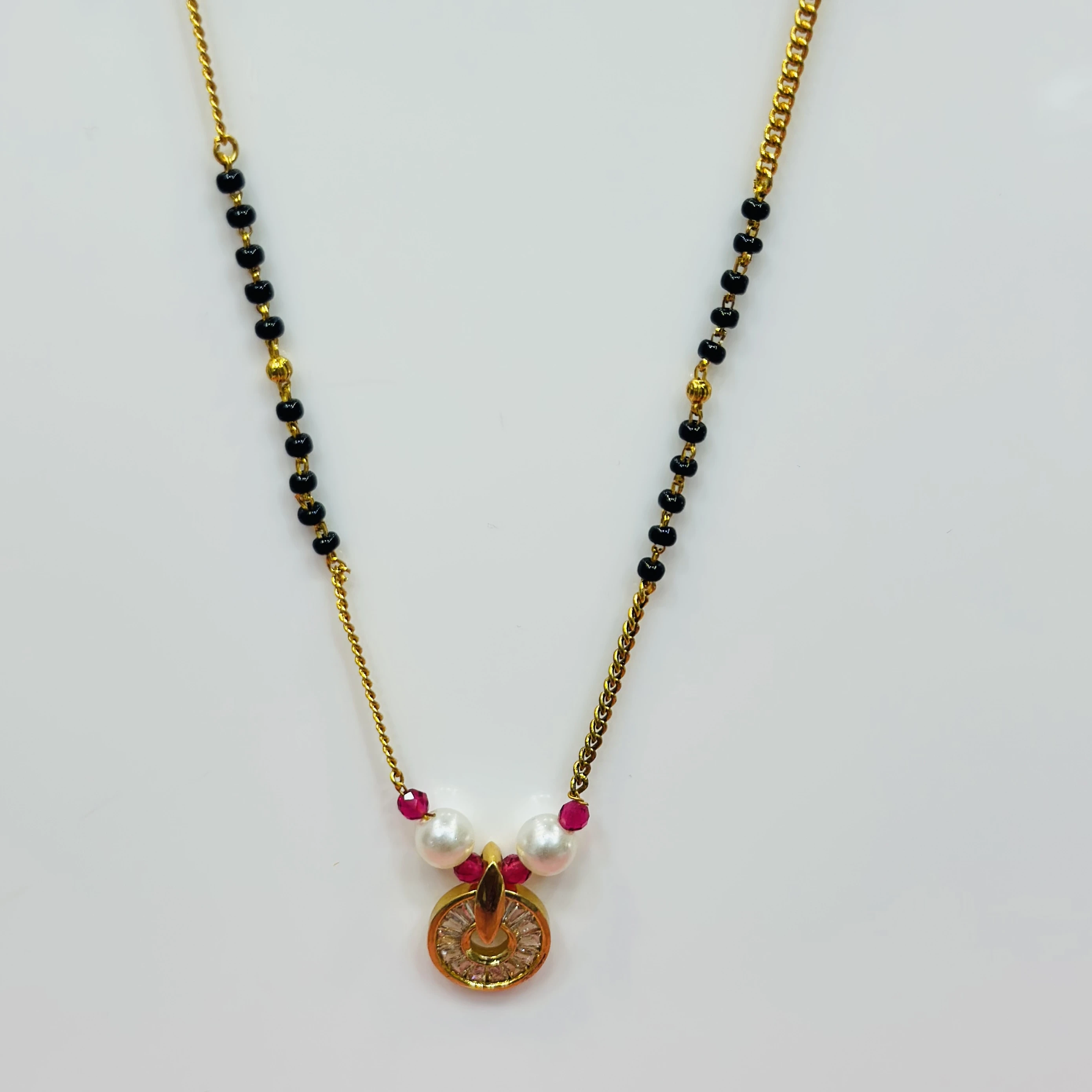 gold-plated cubic zirconia and pearl mangalsutra with red accents.