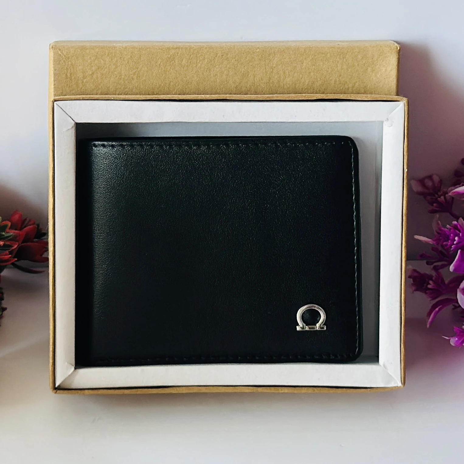 Ferragamo Gancini bi-fold wallet in black calf leather.