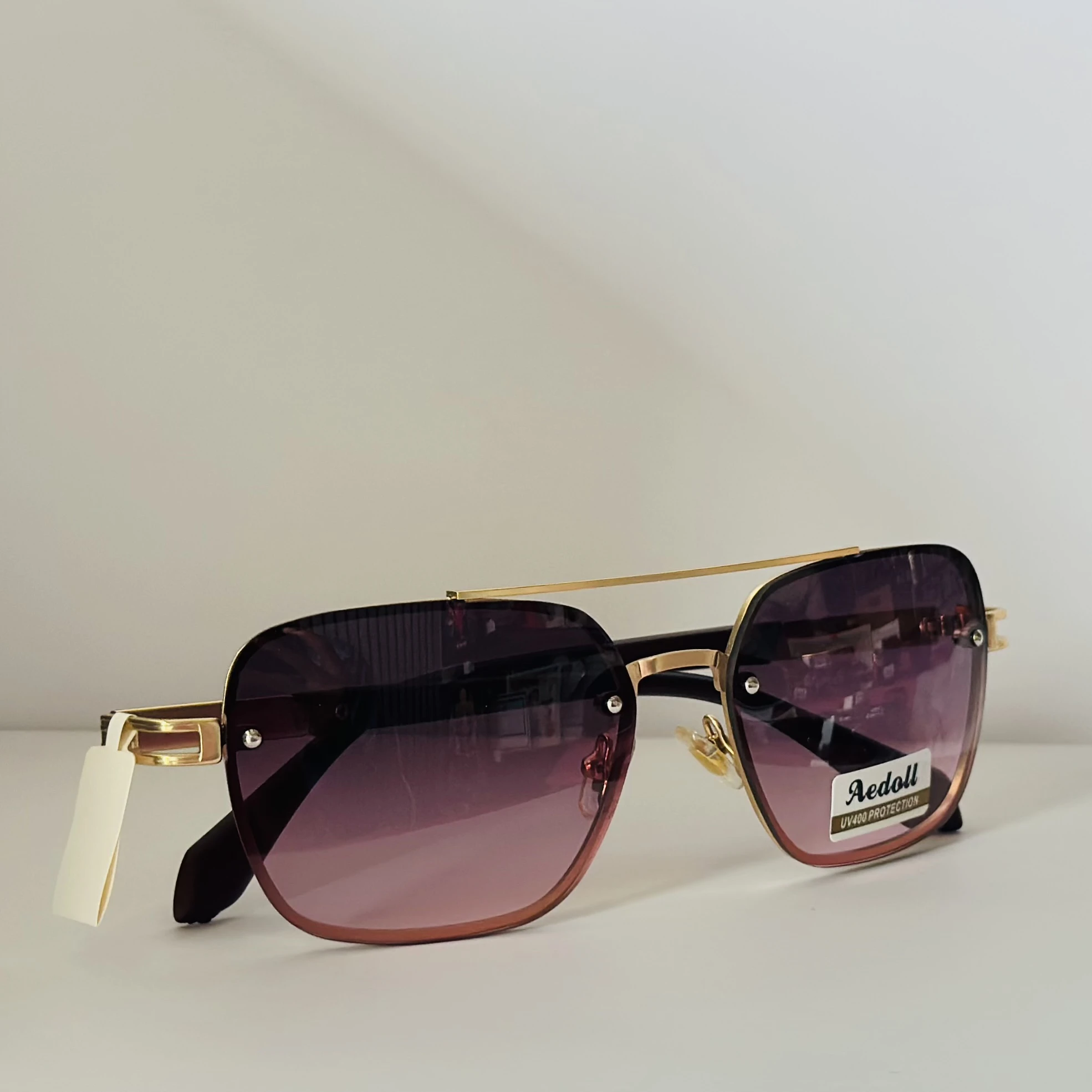pair of Aedoll Goggle sunglasses with a gold metal frame and pink gradient lenses.