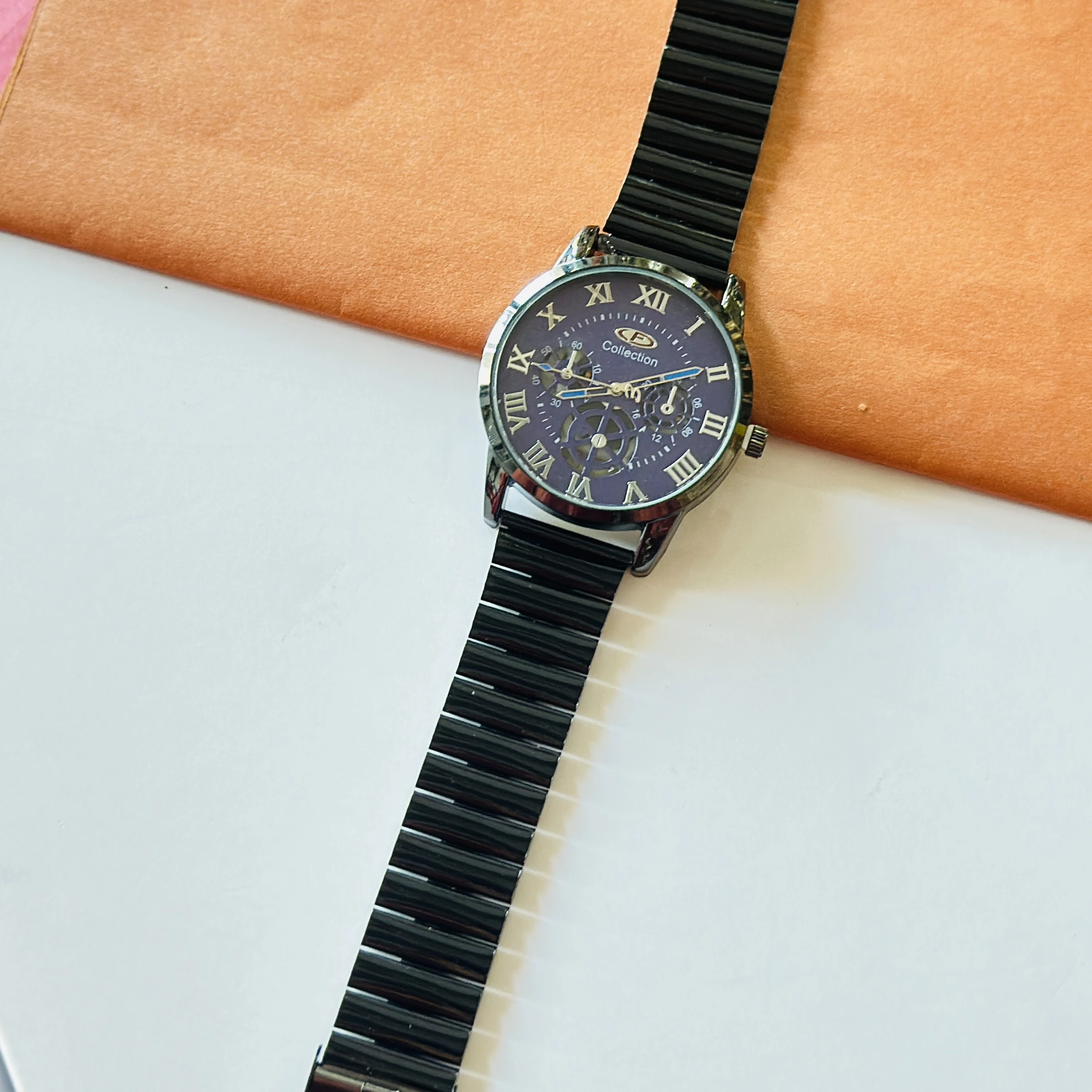 Black stainless steel OLEVS analog watch for men with a blue roman numeral dial.