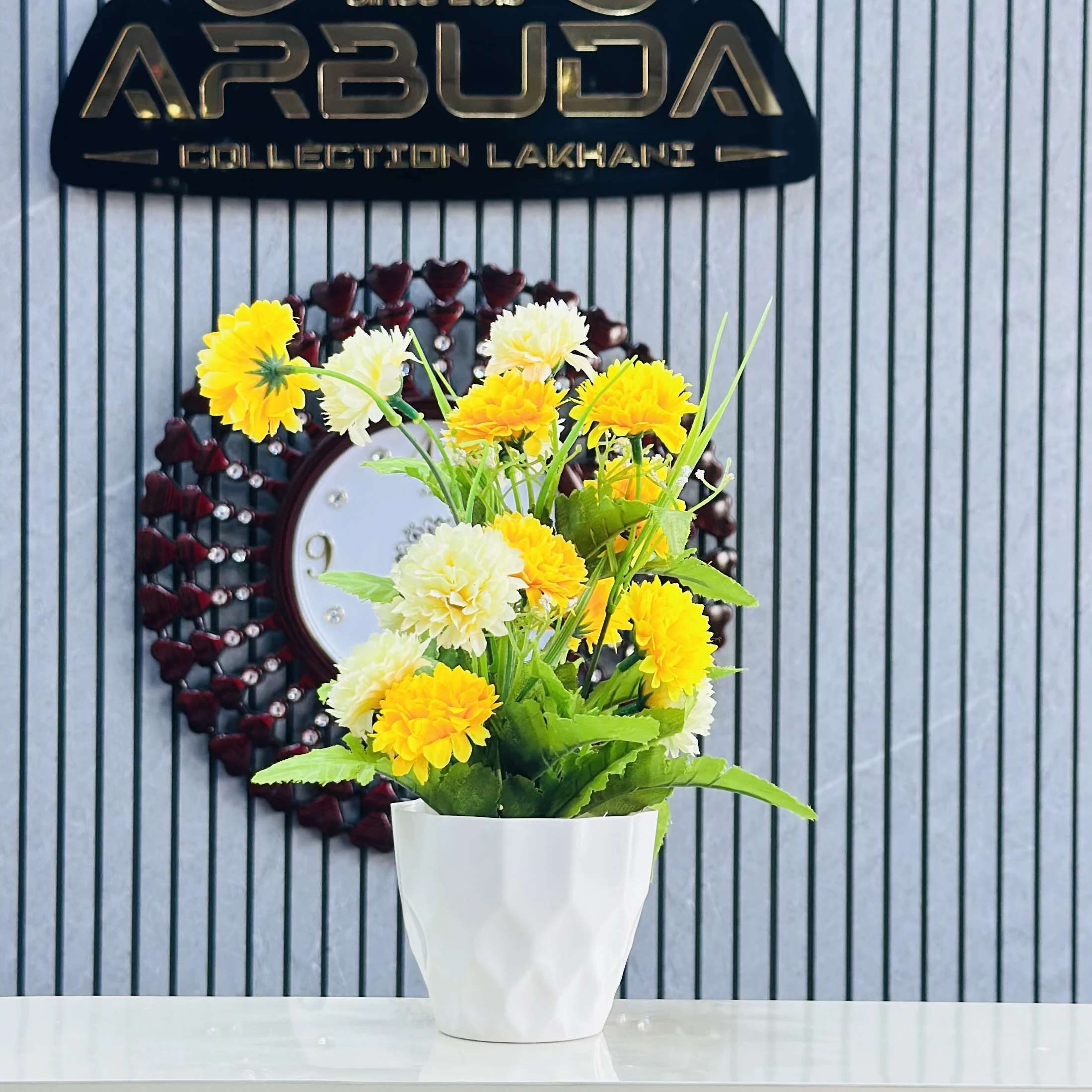 an artificial flower arrangement in a white pot.