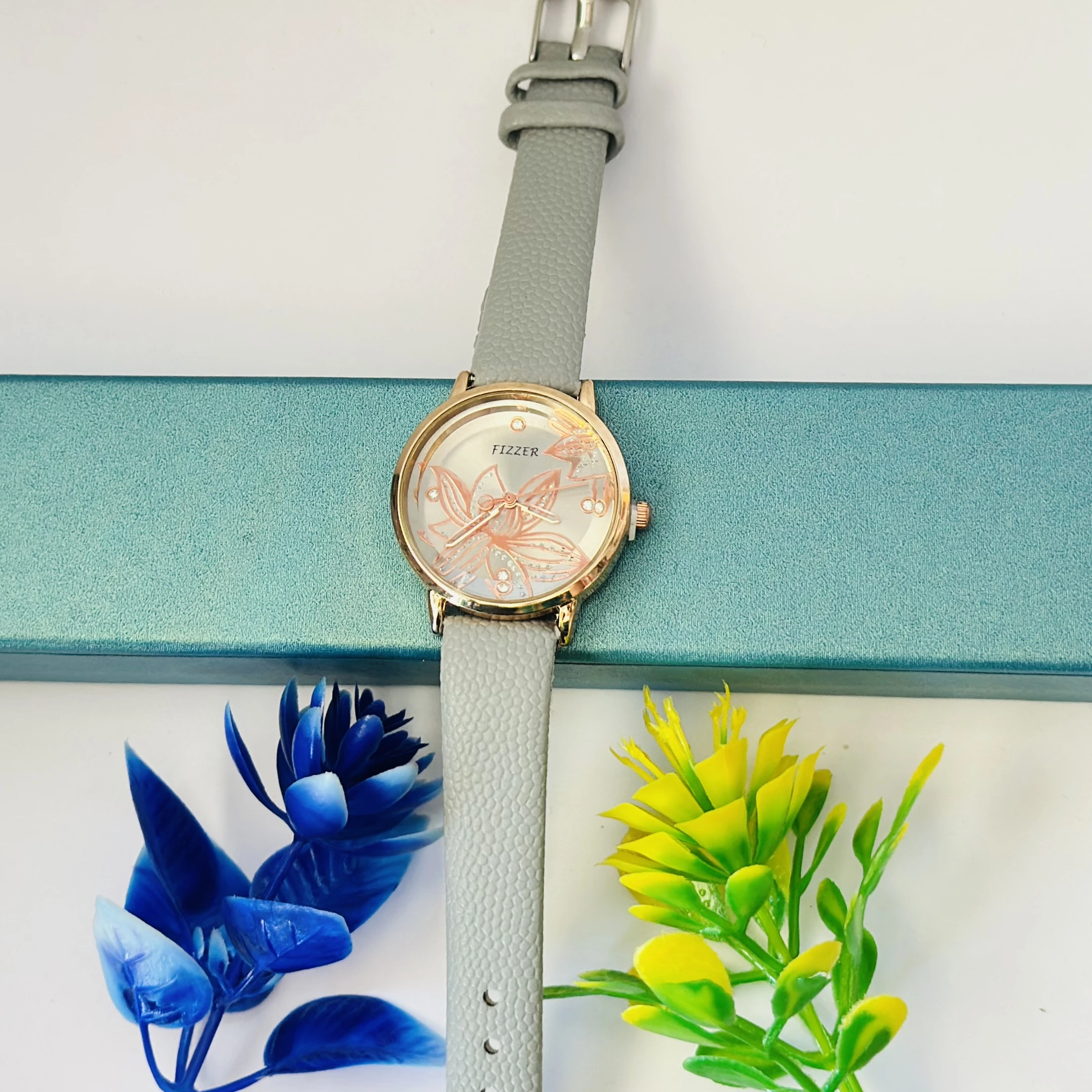 Fizzer women's analog watch with a grey leather strap and a floral-printed dial.