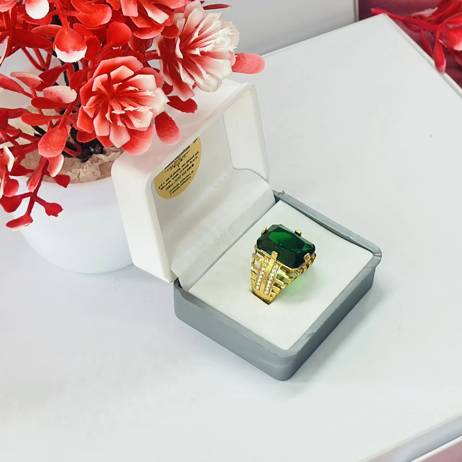 Gold plated men's ring with a green artificial stone and white artificial diamonds.