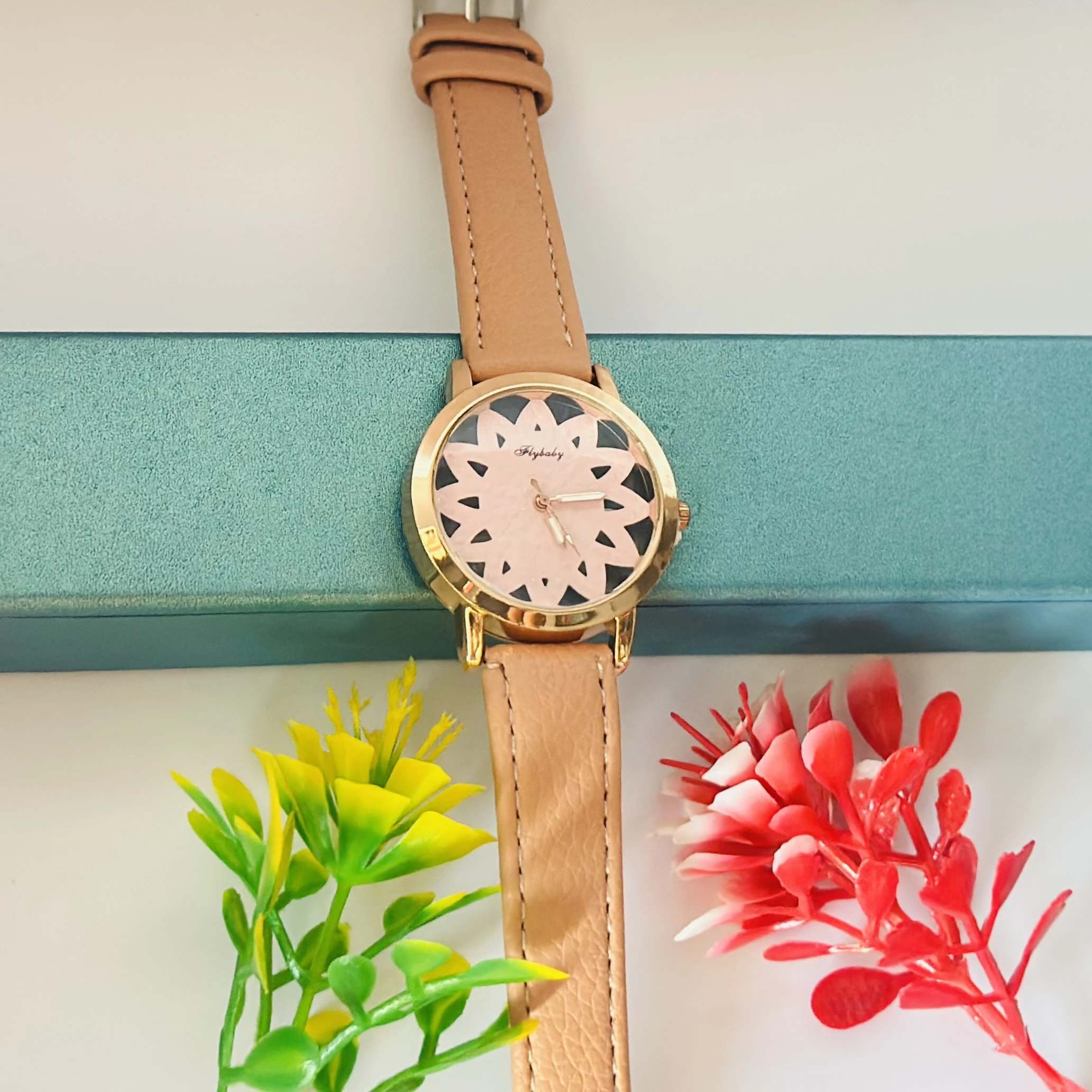 Flybaby flower watch with a peach/tan faux leather strap.